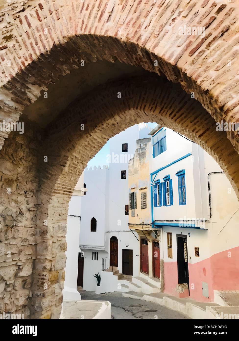 Rue colorée encadrée par une arche en pierre rustique dans le quartier historique de Tanger – 29 Nov 2019.Tanger, Maroc Banque D'Images