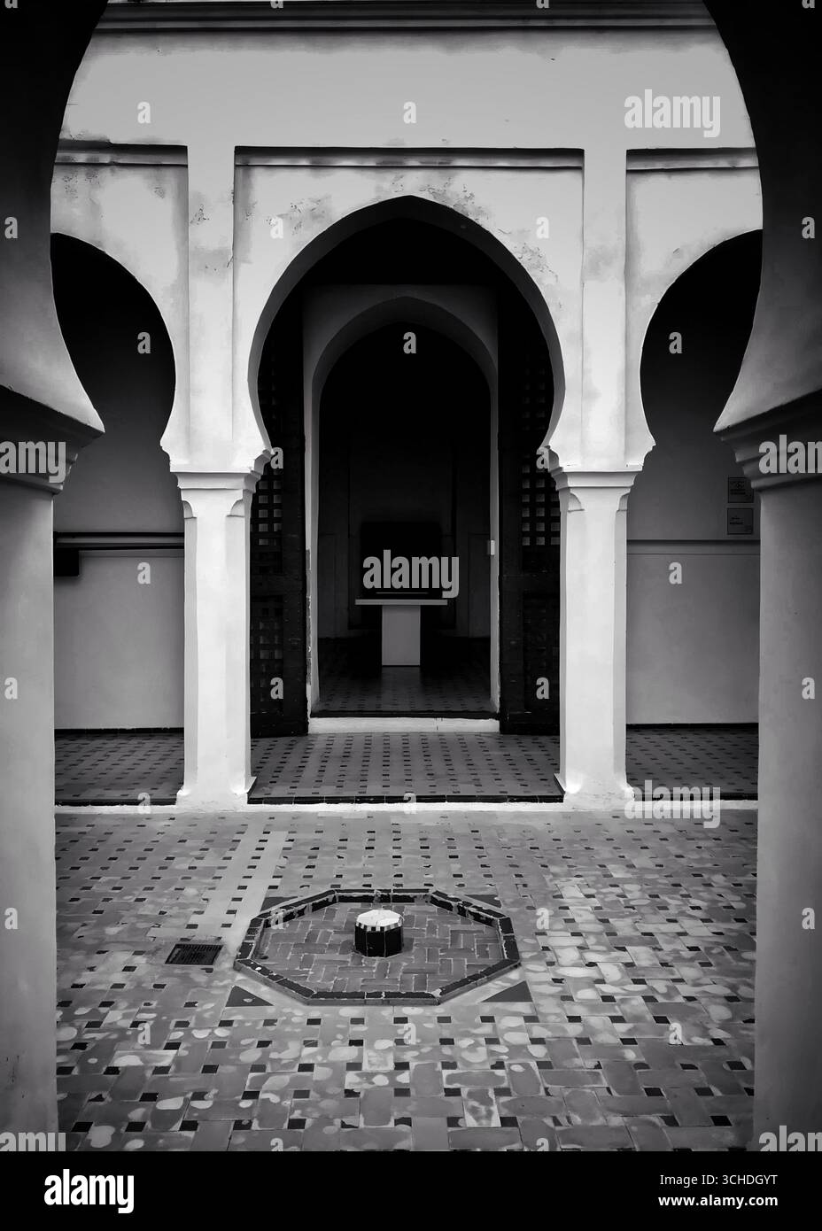 Vue en noir et blanc d’une cour islamique traditionnelle à Tanger, avec des arches pointues, des sols carrelés et une fontaine centrale – 30 novembre 2019. Banque D'Images