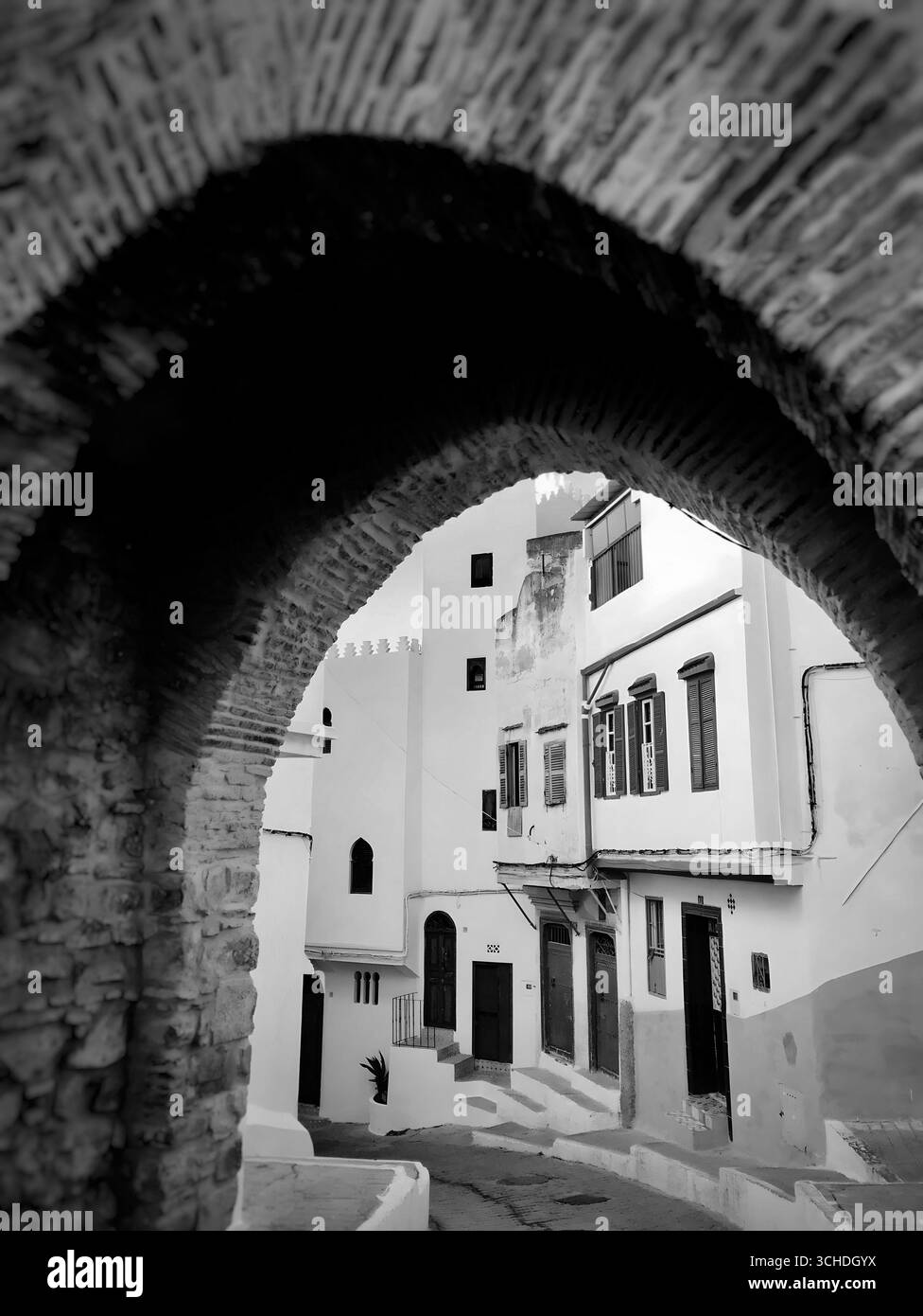 Rue colorée encadrée par une arche en pierre rustique dans le quartier historique de Tanger – 29 Nov 2019.Tanger, Maroc Banque D'Images