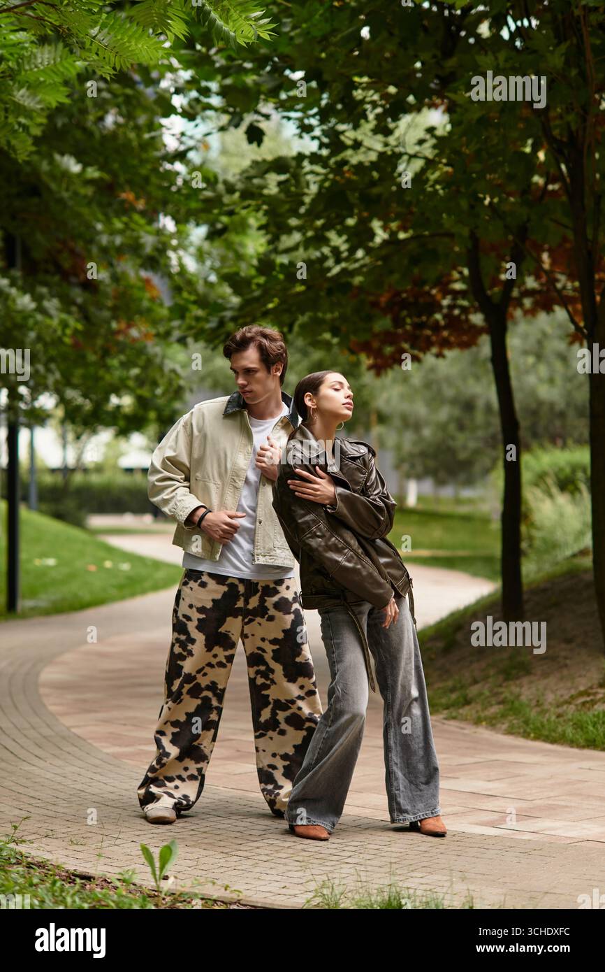 Un couple aimant se tient ensemble dans un parc paisible, embrassant la chaleur de leur connexion. Banque D'Images