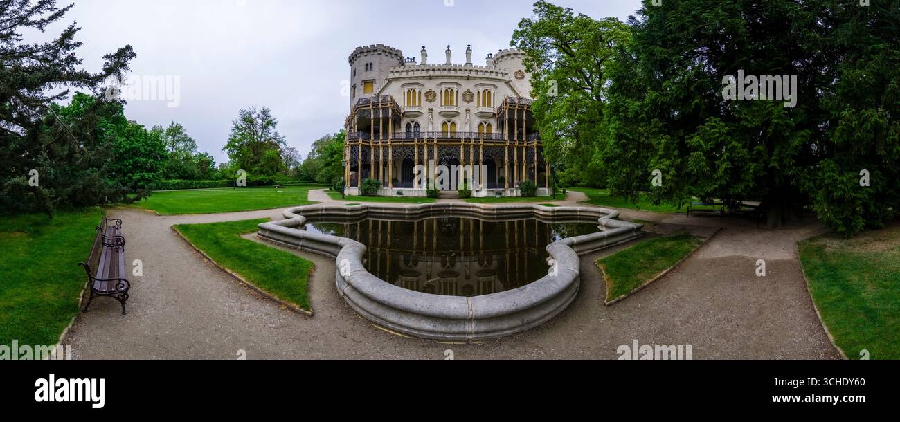 Vue panoramique sur le château de Hluboká, Zámek Hluboká, un château néo-gothique reflété dans un bassin d'eau dans le parc. Banque D'Images