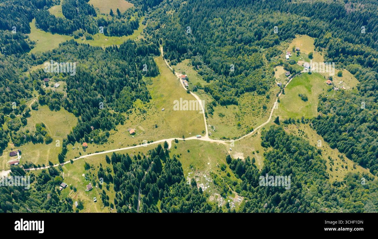 Vue aérienne du paysage de montagne avec des routes rurales, des maisons et des forêts en été Banque D'Images