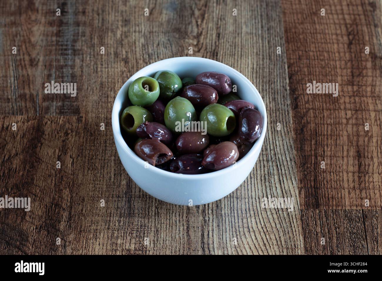 Un petit bol d'olives vertes et noires servit d'accompagnement ou d'apéritif Banque D'Images