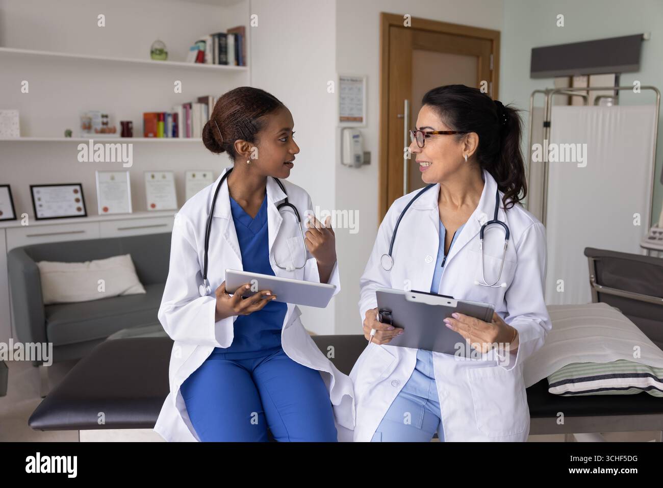 Deux femmes médecins professionnelles s'engagent dans la conversation au cabinet clinique Banque D'Images
