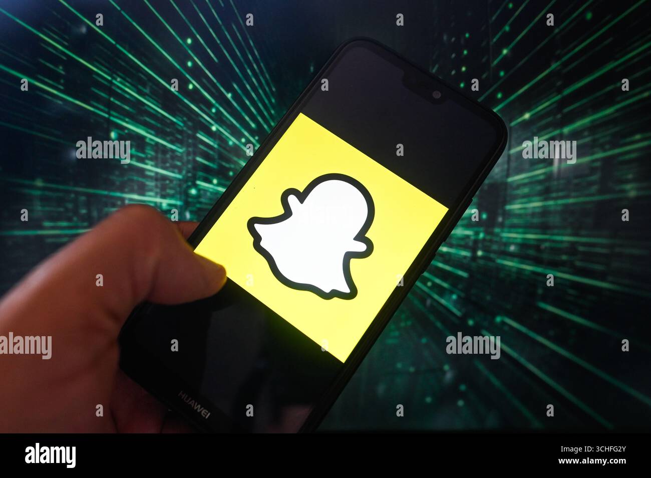 Dans cette illustration photo, un logo Snapchat est affiché sur un smartphone avec des lignes de code sur le fond. Banque D'Images