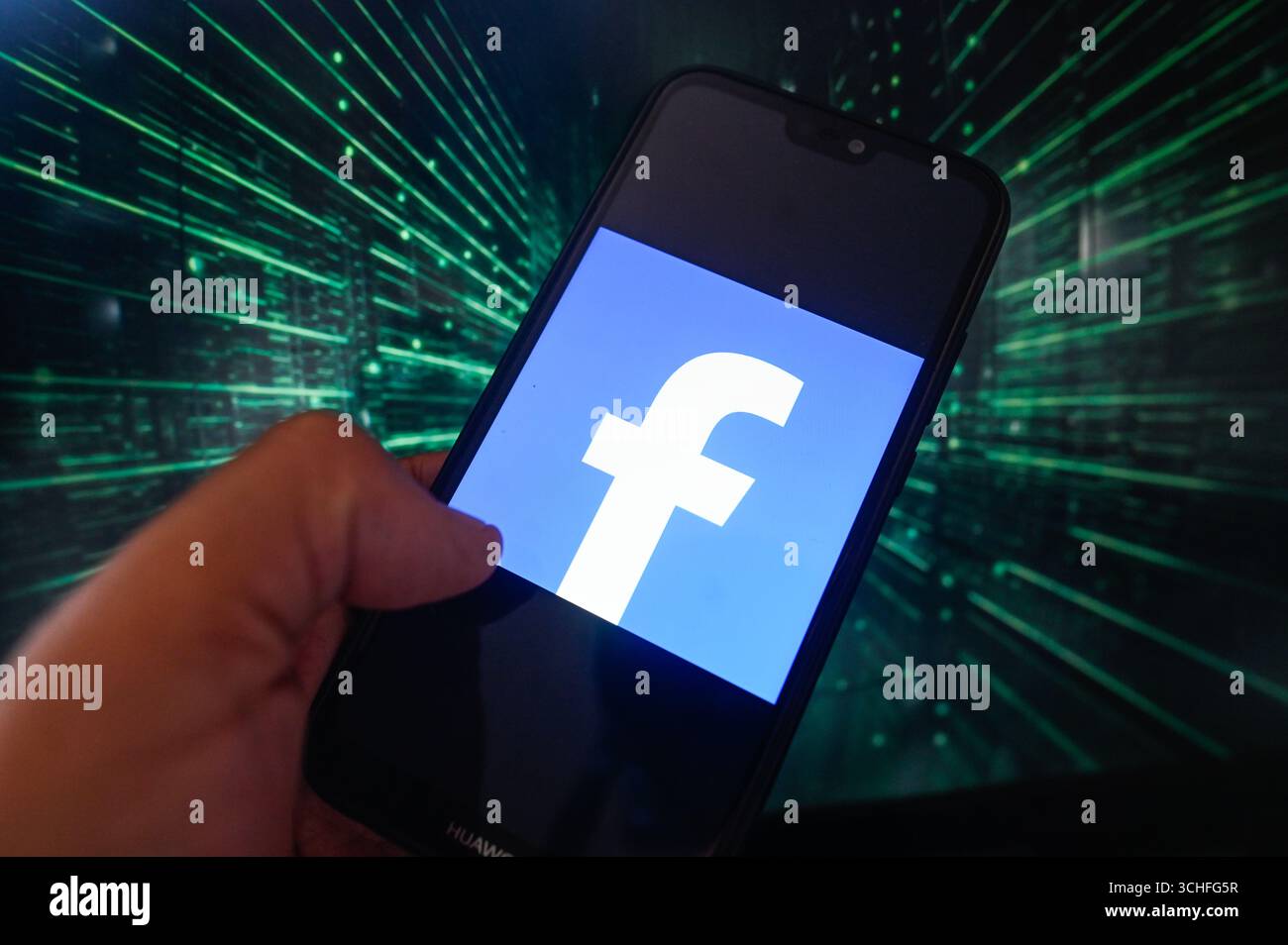 Dans cette illustration photo, un logo Facebook est affiché sur un smartphone avec des lignes de code sur le fond. Banque D'Images