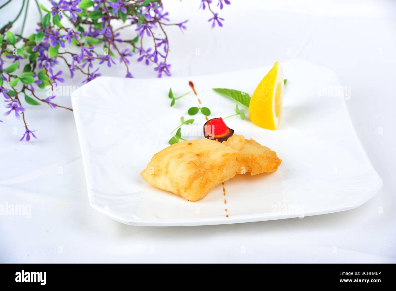 Filet de morue poêlé avec citron sur assiette blanche Banque D'Images