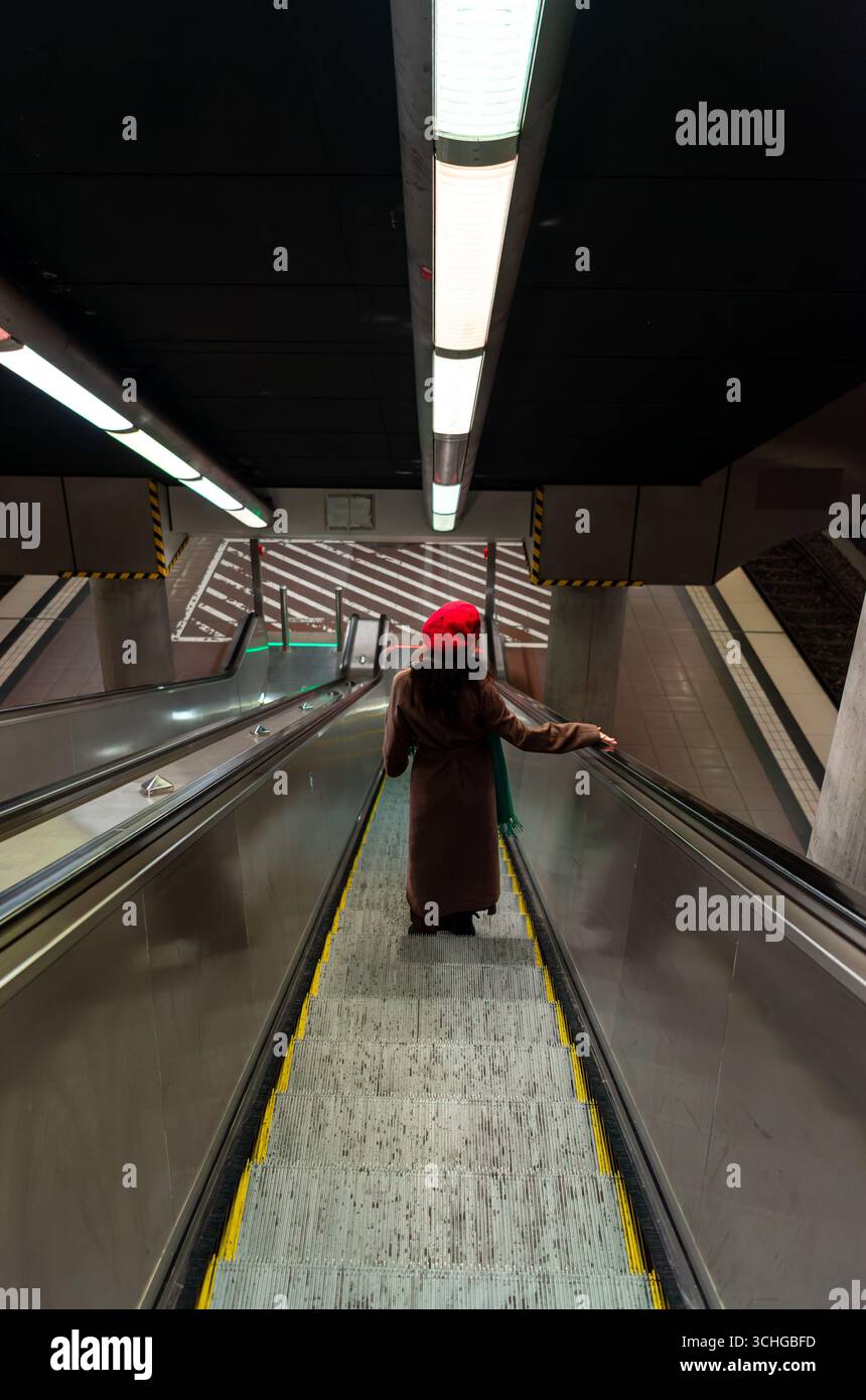 Femme utilisant des escaliers roulants dans la station de métro de l'aéroport de Stuttgart Banque D'Images