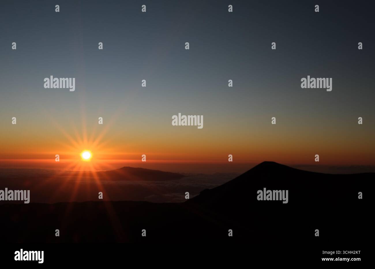 Coucher de soleil au-dessus des nuages depuis le sommet du Mauna Kea, HawaiiBig Island Hawaii. Banque D'Images