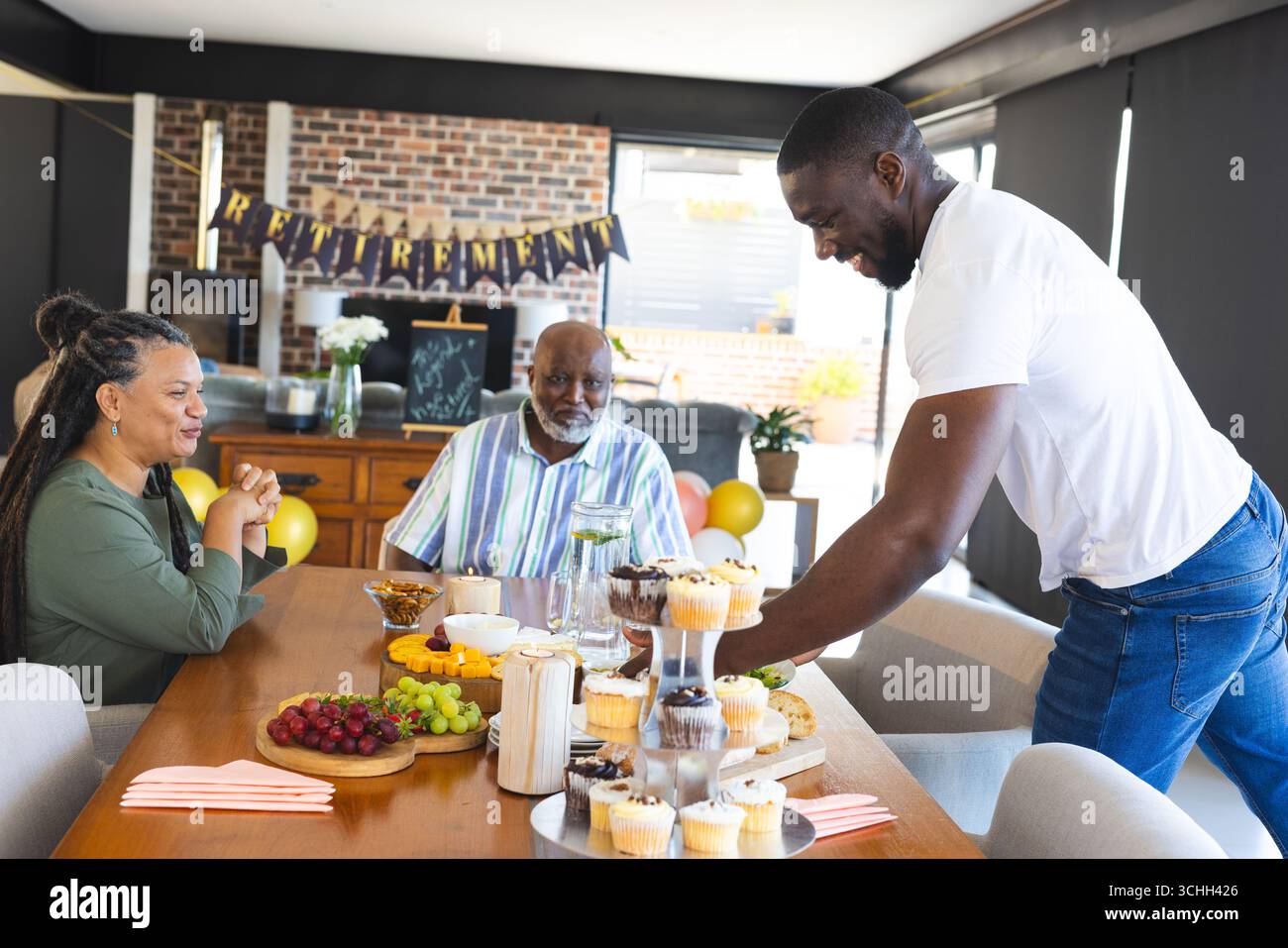 Célébrer la retraite, partager des cupcakes et des fruits en famille, profiter de moments joyeux ensemble Banque D'Images