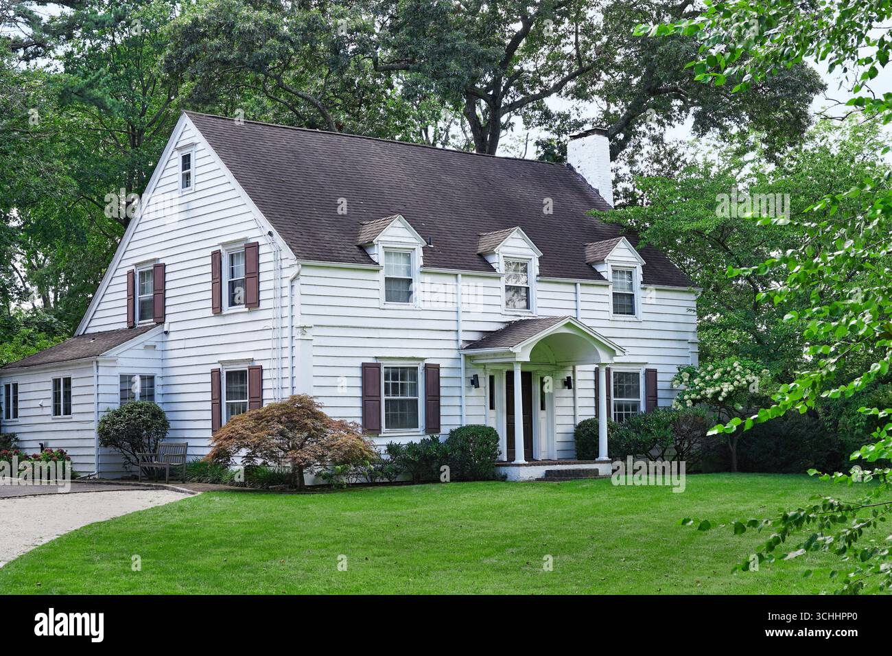 Maison à claquettes de deux étages entourée d'arbres Banque D'Images