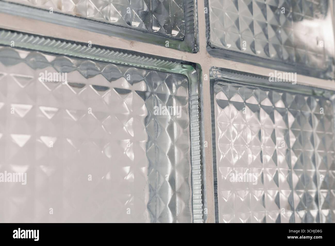 Vue rapprochée de blocs de verre transparents aux textures variées laissant passer la lumière. Le design crée un effet visuel intéressant dans un mépris Banque D'Images