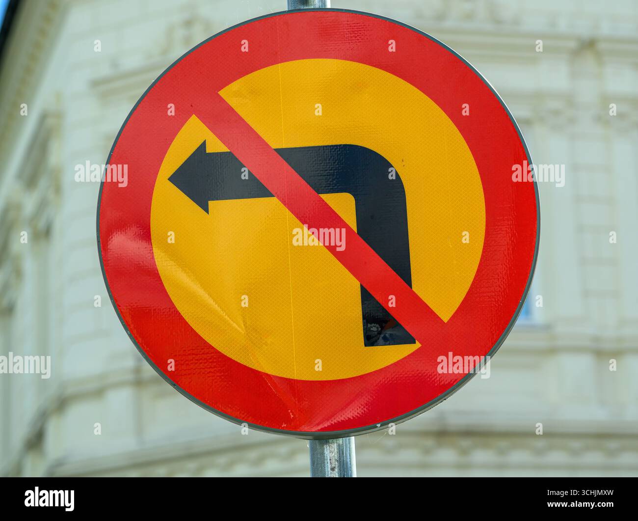 Un panneau circulaire rouge et jaune affiché sur une rue indique que les virages à gauche sont interdits. Ce panneau a pour but de guider les conducteurs pour une navigation sécuritaire à l'intérieur Banque D'Images