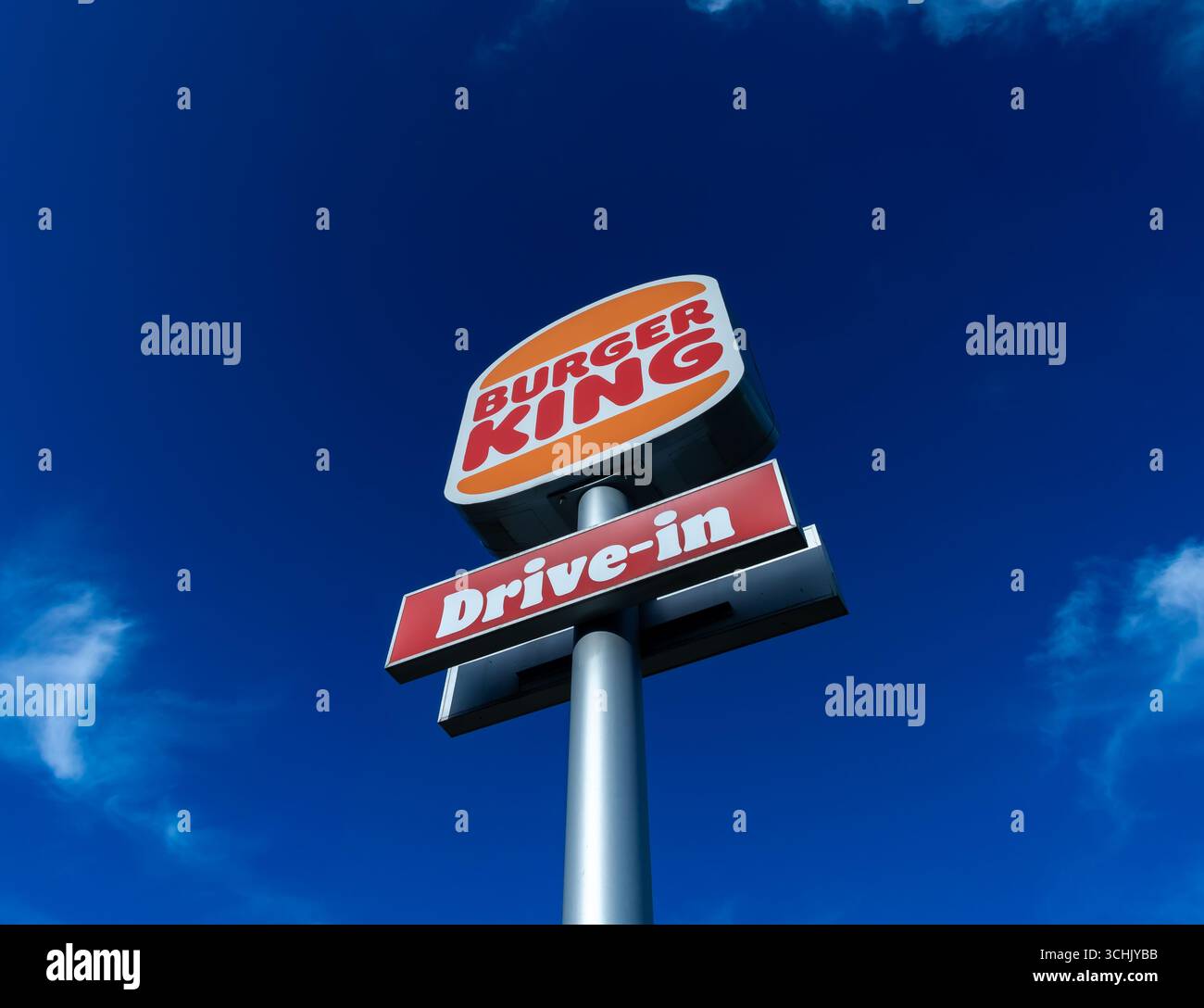 Logo Burger King Drive-In capturé sous un angle bas sous un ciel bleu d'été en Allemagne, mettant en valeur la marque audacieuse de l'entreprise. Banque D'Images