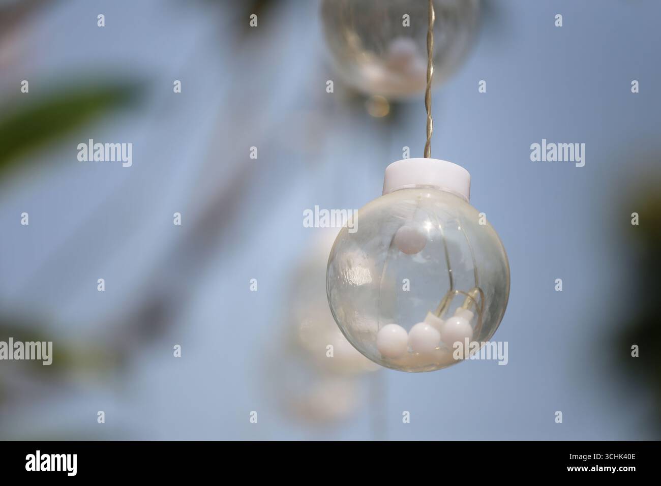 Délicats orbes de verre aux accents blancs accrochent magnifiquement, offrant une touche d'élégance et de charme pour divers événements et rassemblements. Idéal pour ajouter un Banque D'Images