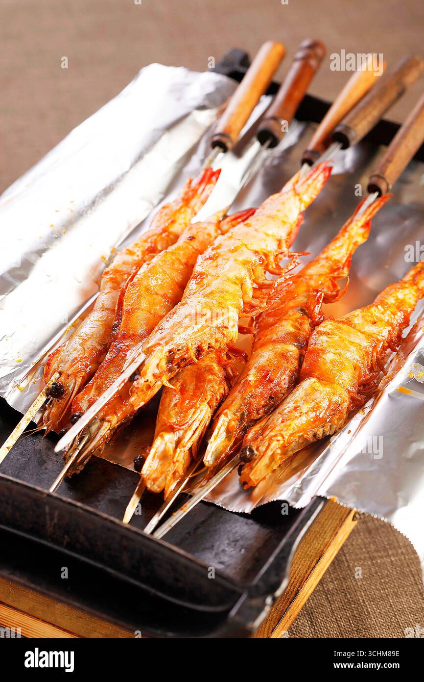 Brochettes de crevettes grillées de style asiatique sur poêle doublée de feuille Banque D'Images