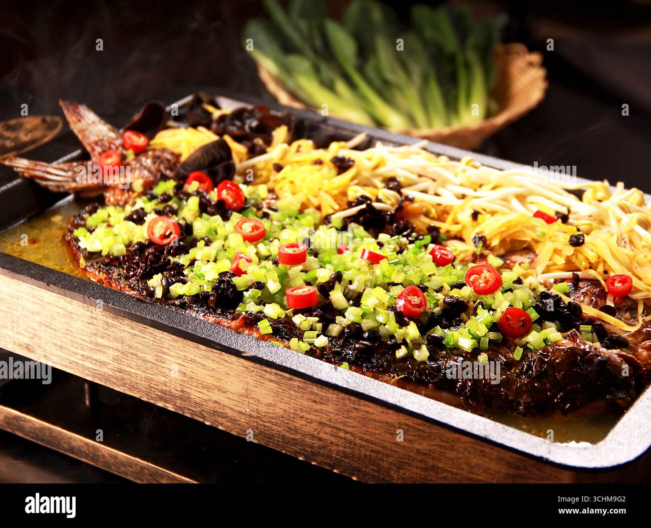 Poisson entier grillé chinois avec haricots noirs et Chili sur plateau chaud Banque D'Images