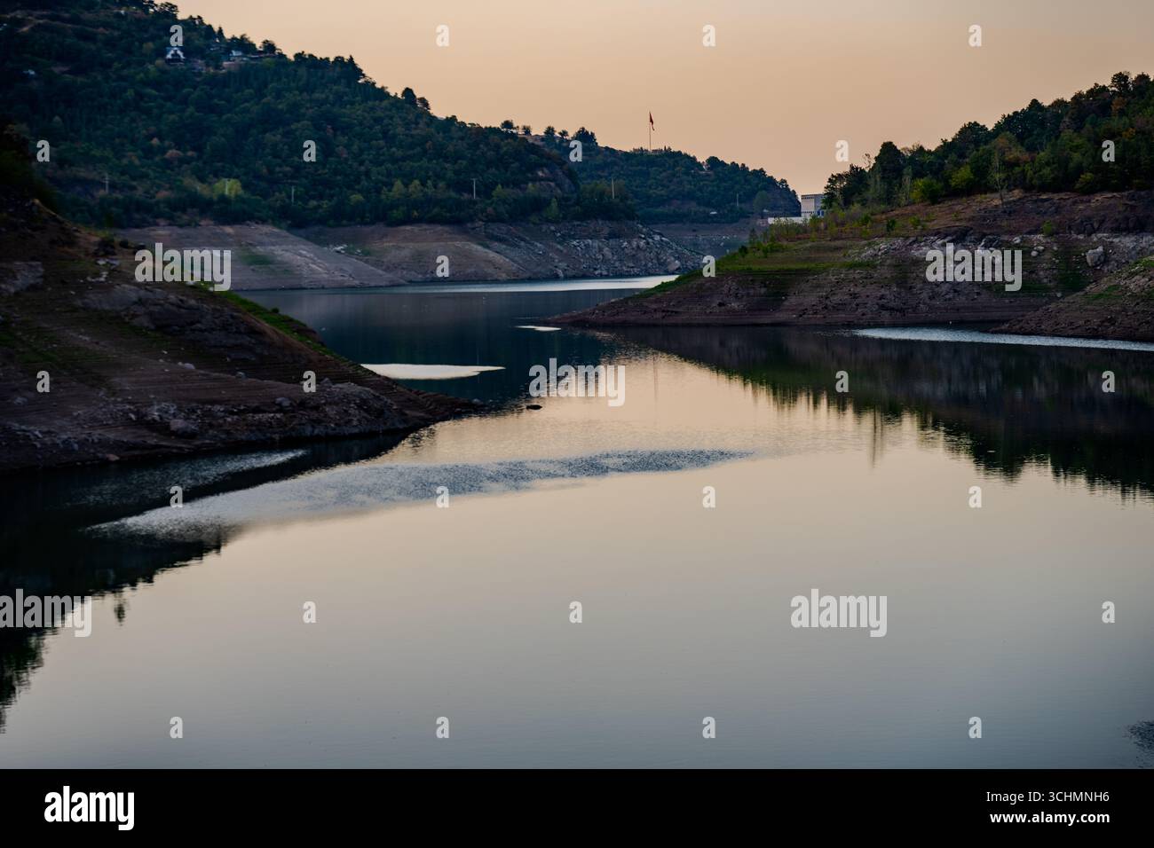Une vue tranquille sur le lac Yuvacık Dam avec les collines environnantes et l'eau réfléchissante calme pendant le coucher du soleil à Yuvacık Yakacık, Başiskele, Kocaeli, Turquie - au Banque D'Images
