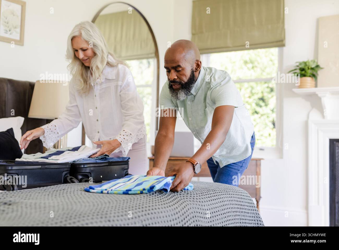 Couple emballant la valise sur le lit, se préparant pour le voyage d'une journée de mariage ensemble Banque D'Images