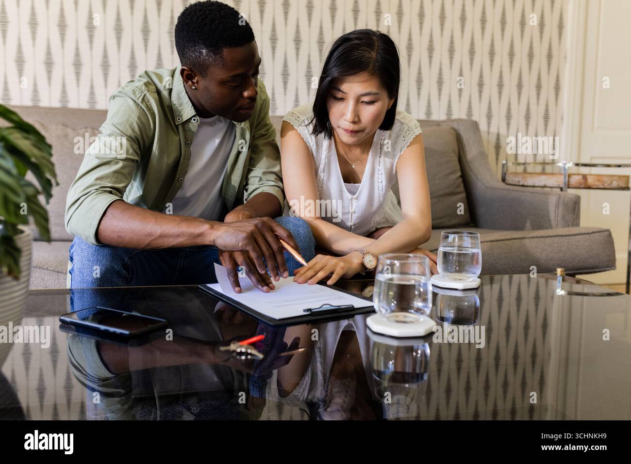 Couple planifiant les détails du mariage ensemble à la maison, axé sur les notes et les idées Banque D'Images