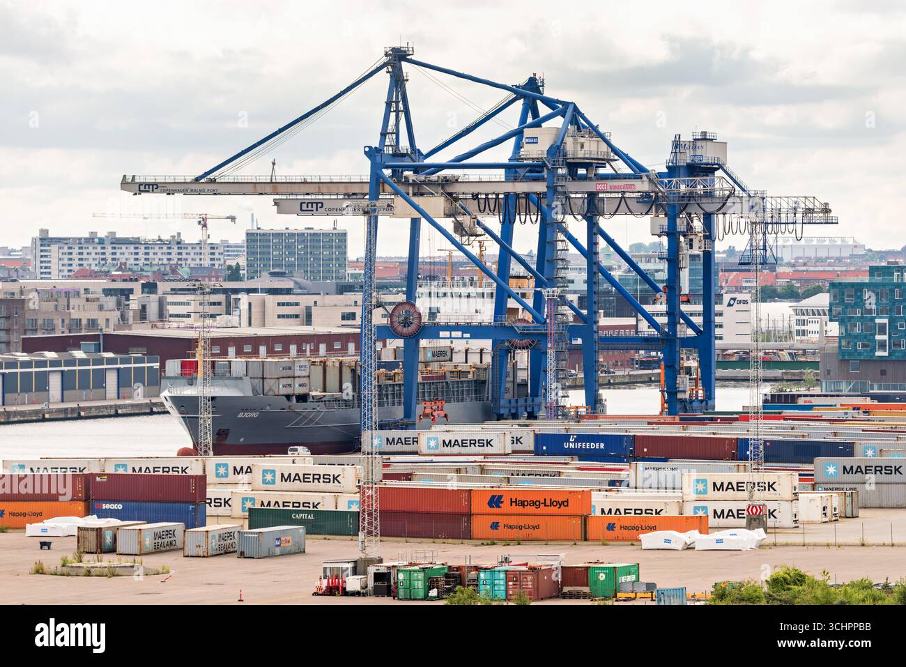 Navire porte-conteneurs au port de Copenhague Malmo Danemark // COPENHAGUE, Danemark — Un grand navire porte-conteneurs est amarré au port de Copenhague Malmö, une plaque tournante maritime vitale desservant le Danemark et la Suède. Le port dispose de nombreuses grues à portique, essentielles pour le chargement et le déchargement des conteneurs de fret des navires. De nombreux conteneurs maritimes, y compris ceux de Maersk, Hapag-Lloyd et Unifeeder, sont empilés sur le quai. L'infrastructure du port soutient d'importantes opérations de commerce international et de logistique. Le port de Copenhague Malmö est stratégiquement situé dans le détroit de Øresund, ce qui facilite l'efficacité de la circulation Banque D'Images