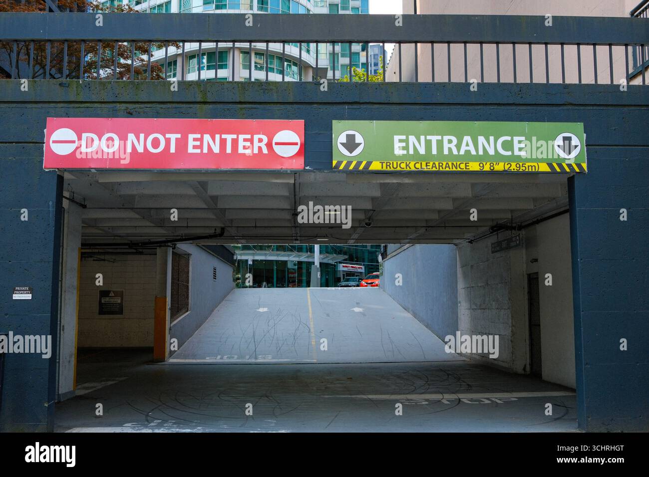 Une pancarte « ne pas entrer » et « entrée » donnant sur un parc de stationnement du centre-ville de Vancouver, en Colombie-Britannique. Banque D'Images