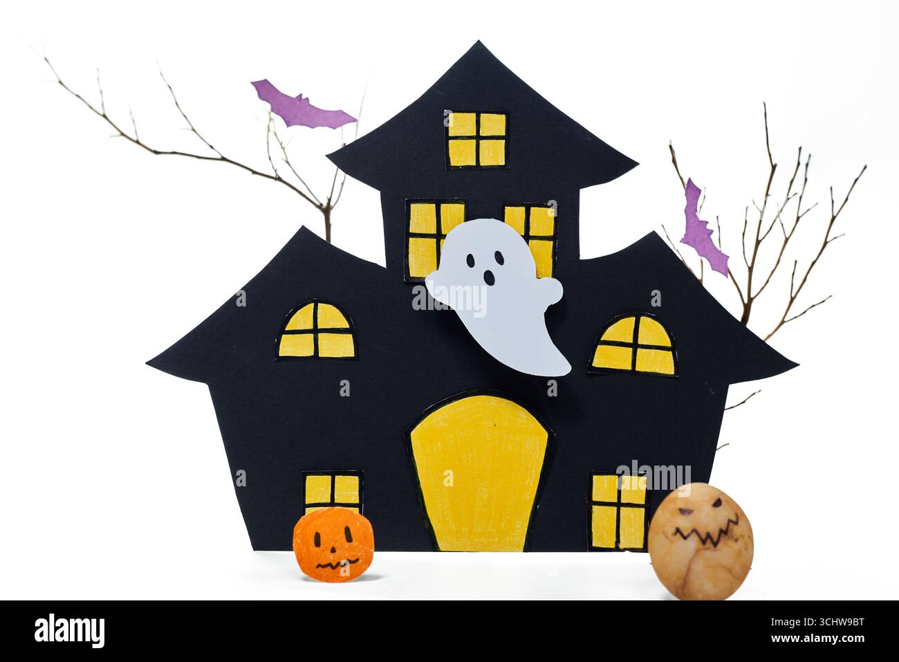 Maison hantée d'Halloween faite à la main avec un fantôme blanc, une citrouille drôle et un monstre rocheux. Une décoration créative et ludique pour la célébration d'Halloween sur w Banque D'Images