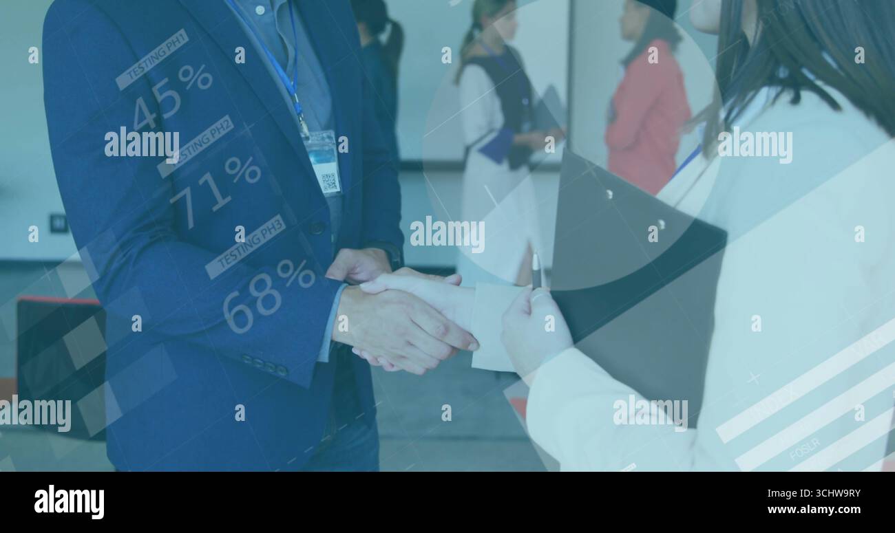 Se serrant la main des associés commerciaux dans la salle de conférence, avec superposition du presse-papiers et des graphiques de données Banque D'Images
