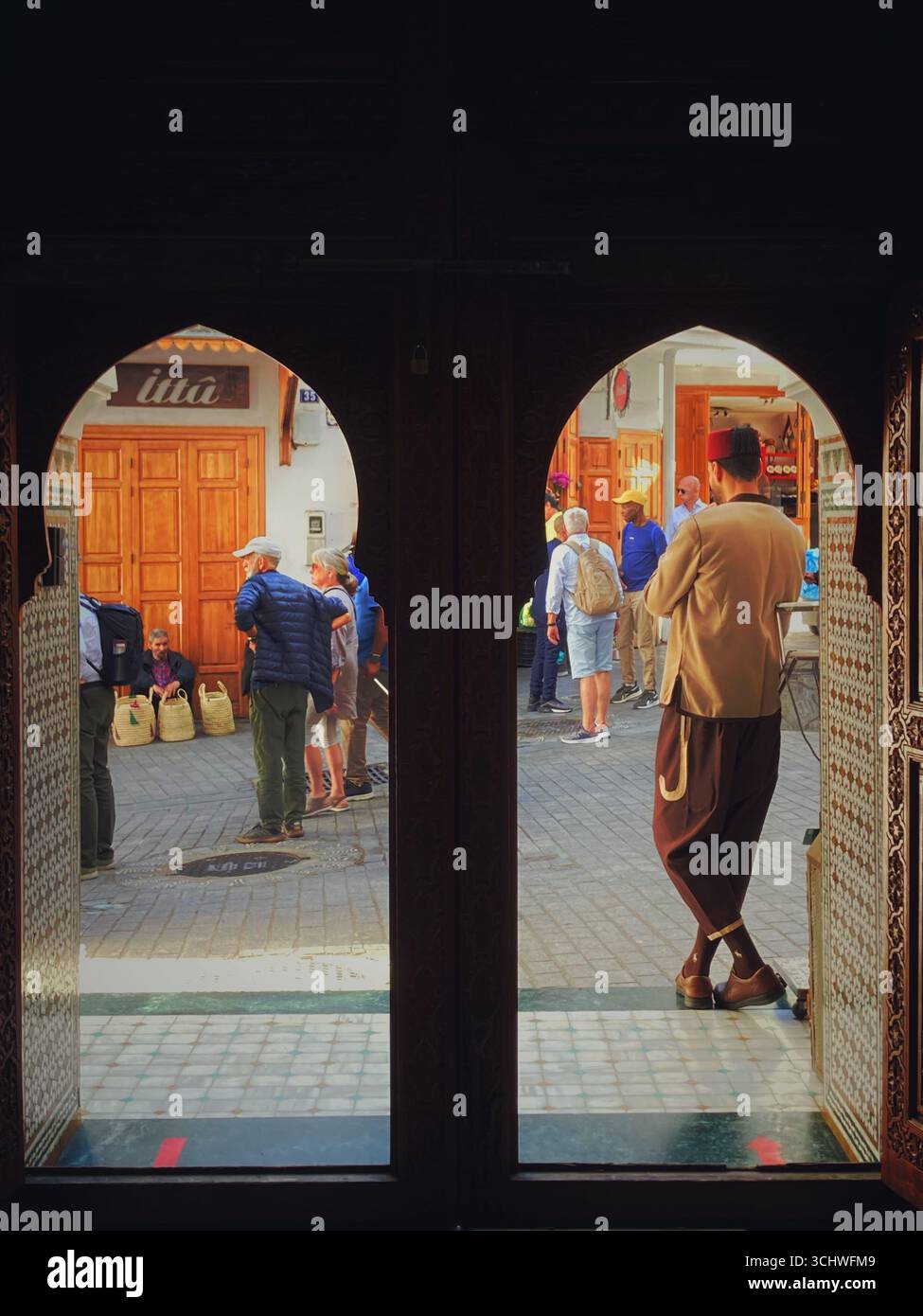 Scène de rue vue à travers une porte à double arche au Café Riyad, Palais Zahia, à Tanger, Maroc. 19 novembre 2024. Banque D'Images