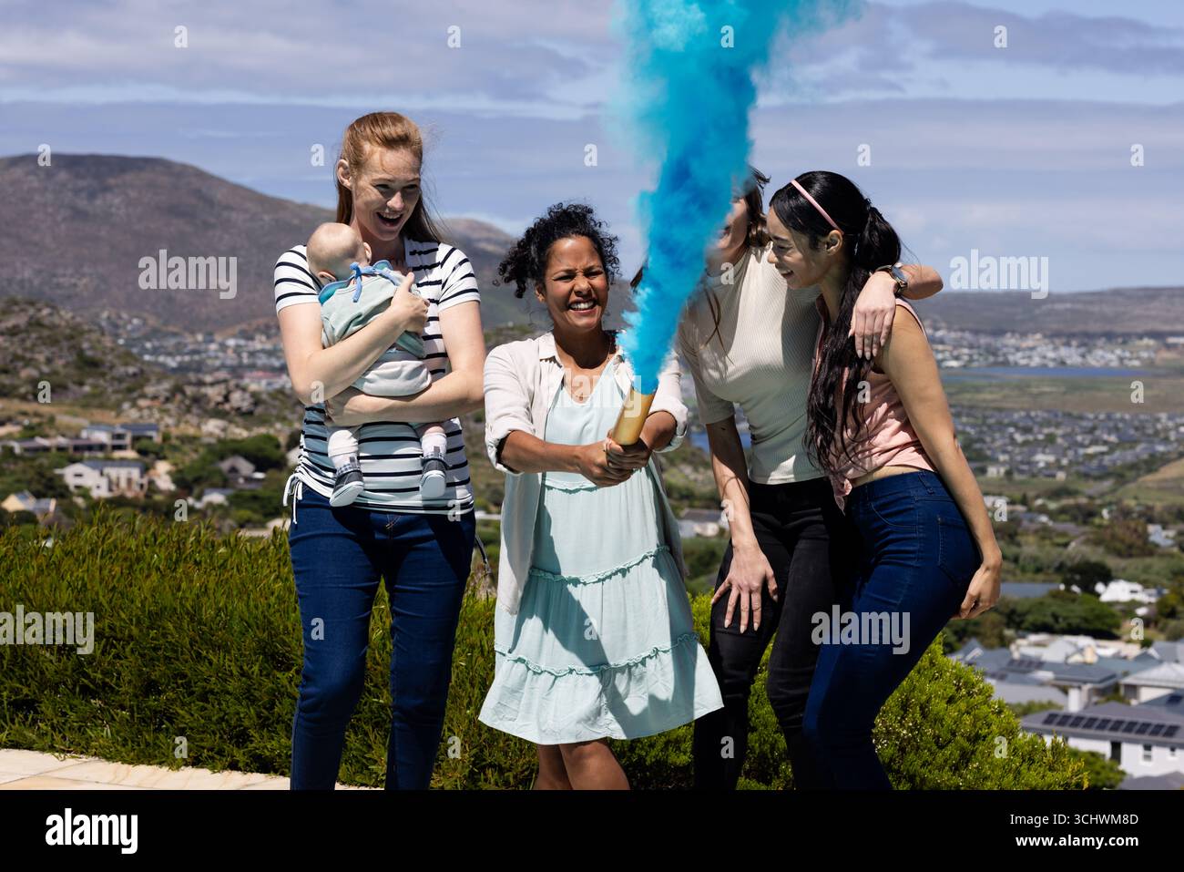 Groupe d'amies féminines diverses célébrant le genre garçon se révèlent avec de la fumée bleue, souriante et joyeuse Banque D'Images
