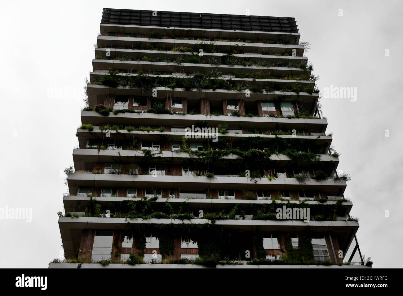 Tour résidentielle étagée avec plantation de balcon dense à Sloterdijk, Amsterdam, pays-Bas, photographiée d'en bas contre un ciel couvert de jour. Banque D'Images