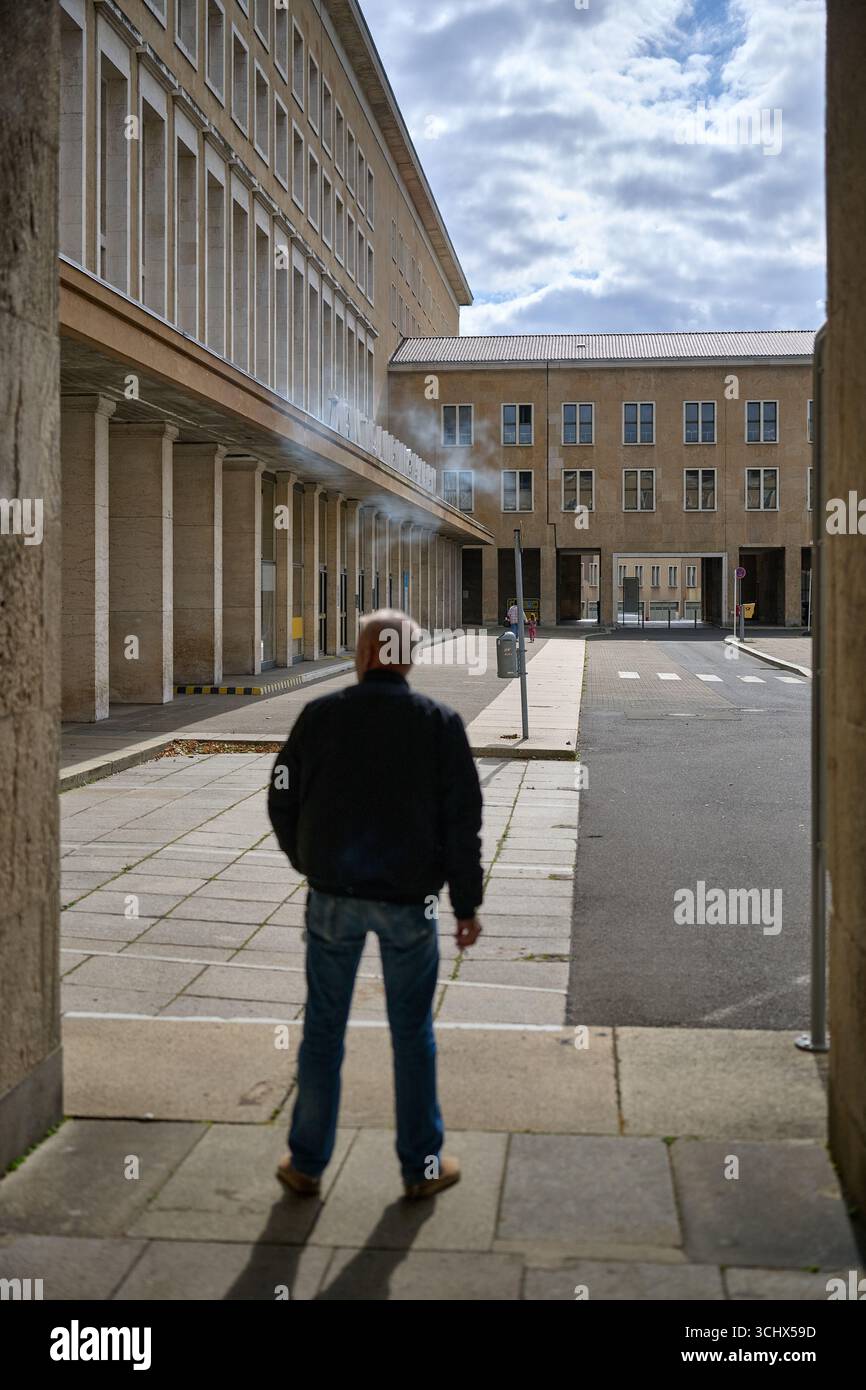 Personne debout, couloir en pierre, aéroport Tempelhof, vue arrière, photo verticale, lumière du jour, humeur contemplative, documentaire, éditorial de voyage, Berlin urb Banque D'Images