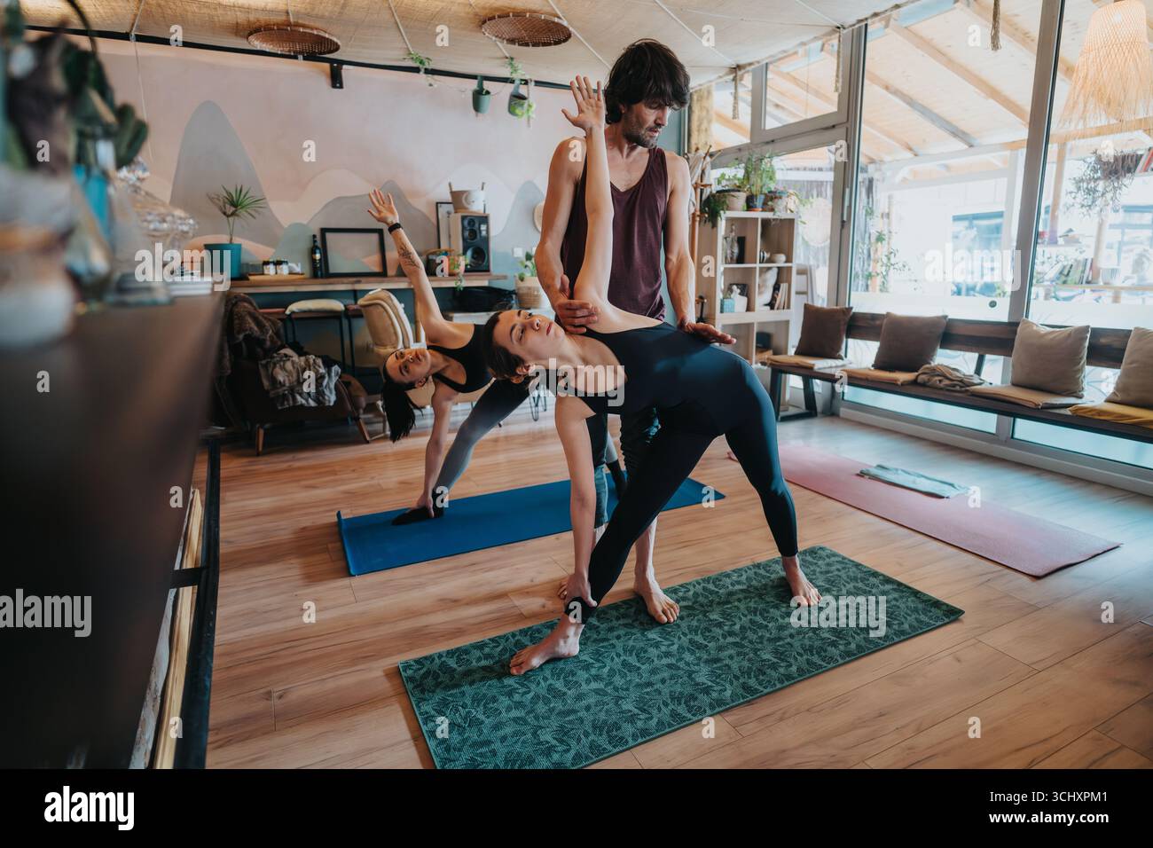 Séance de yoga en groupe guidée par un instructeur dans un environnement de studio serein Banque D'Images