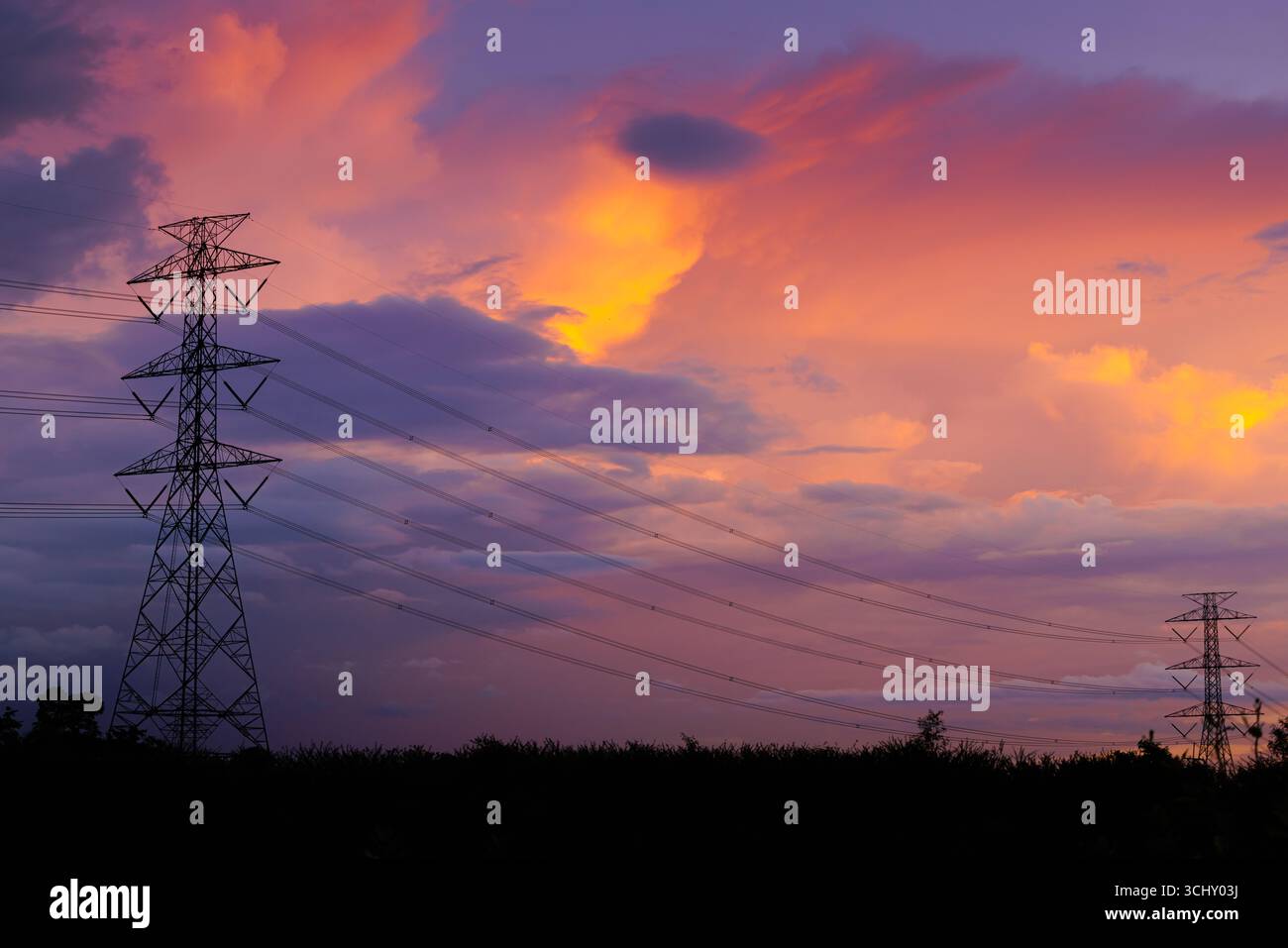 Electricity ligne électrique, tour de transmission d'énergie haute tension à urbain contre le crépuscule aube ciel crépusculaire. Banque D'Images
