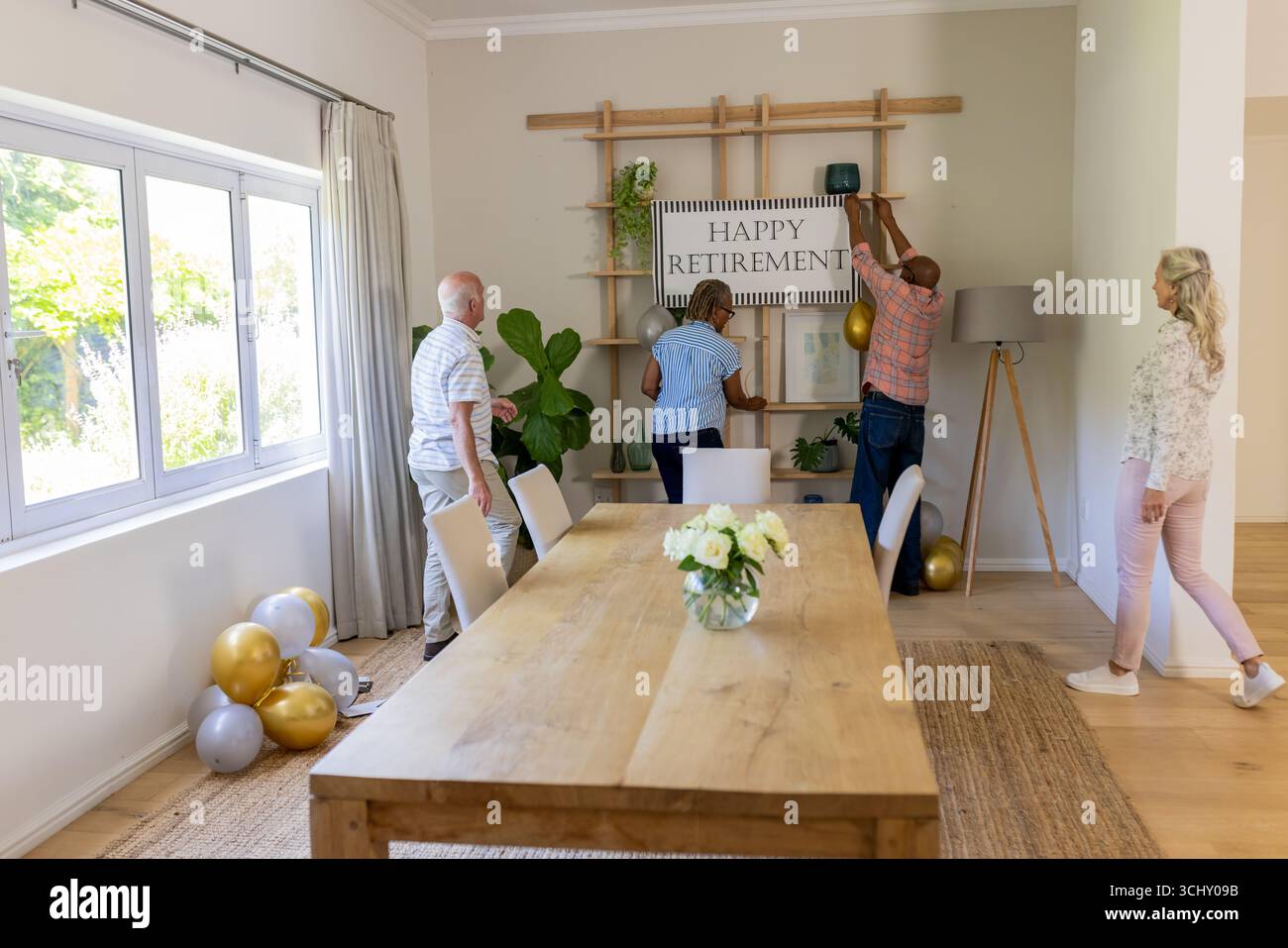 Décoration de la salle avec la bannière de retraite heureuse, amis seniors préparant la célébration Banque D'Images
