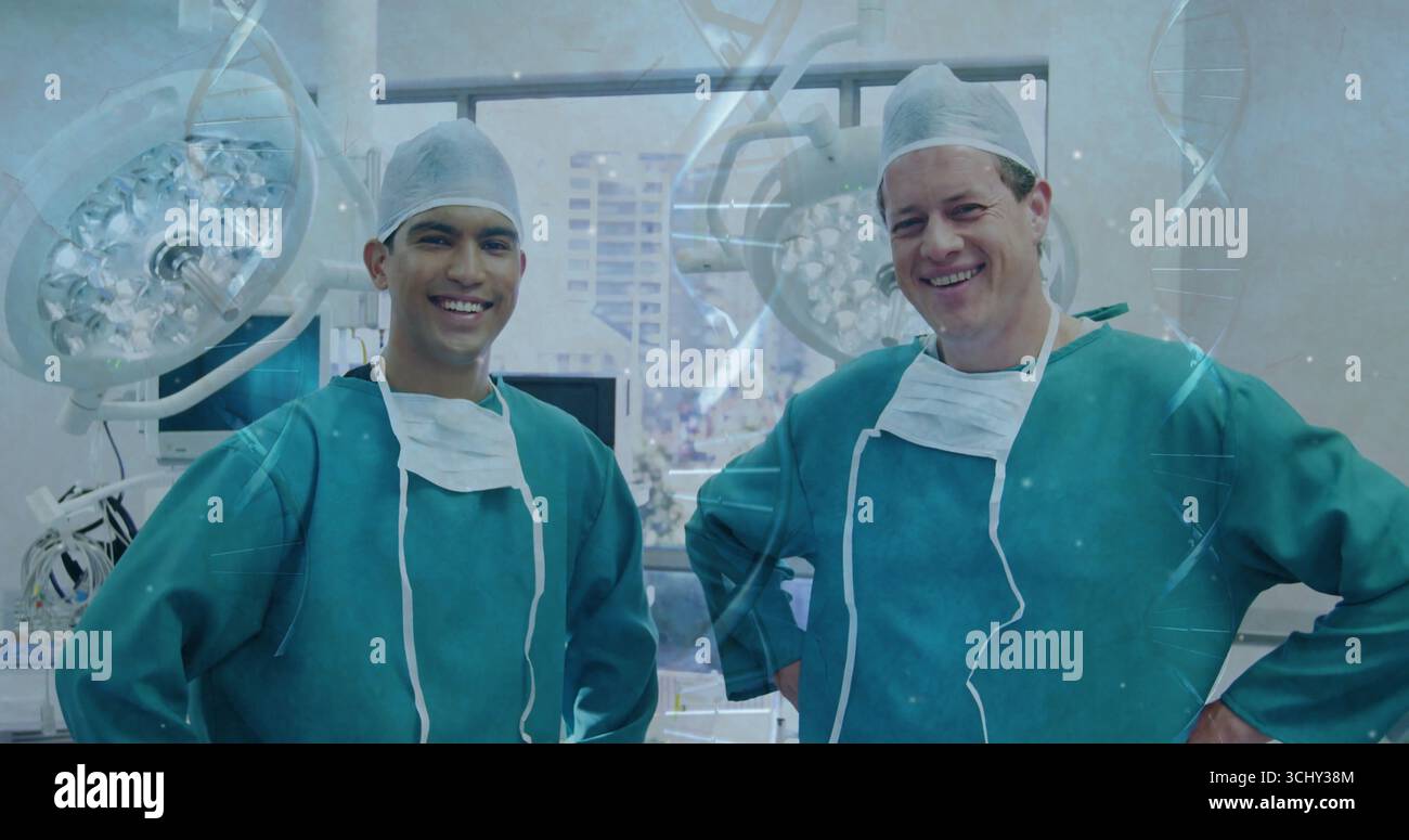 Deux chirurgiens en robe verte debout dans la salle d'opération, avec plafonniers et moniteurs Banque D'Images