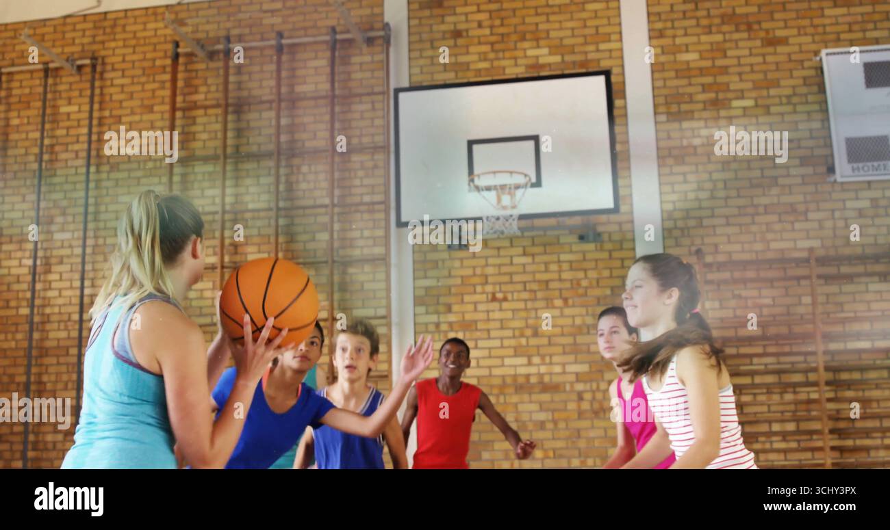 Tenant le basket-ball, athlète débardeur sarcelle se préparant à passer à la salle de gym de l'école avec cerceau, espace de copie Banque D'Images