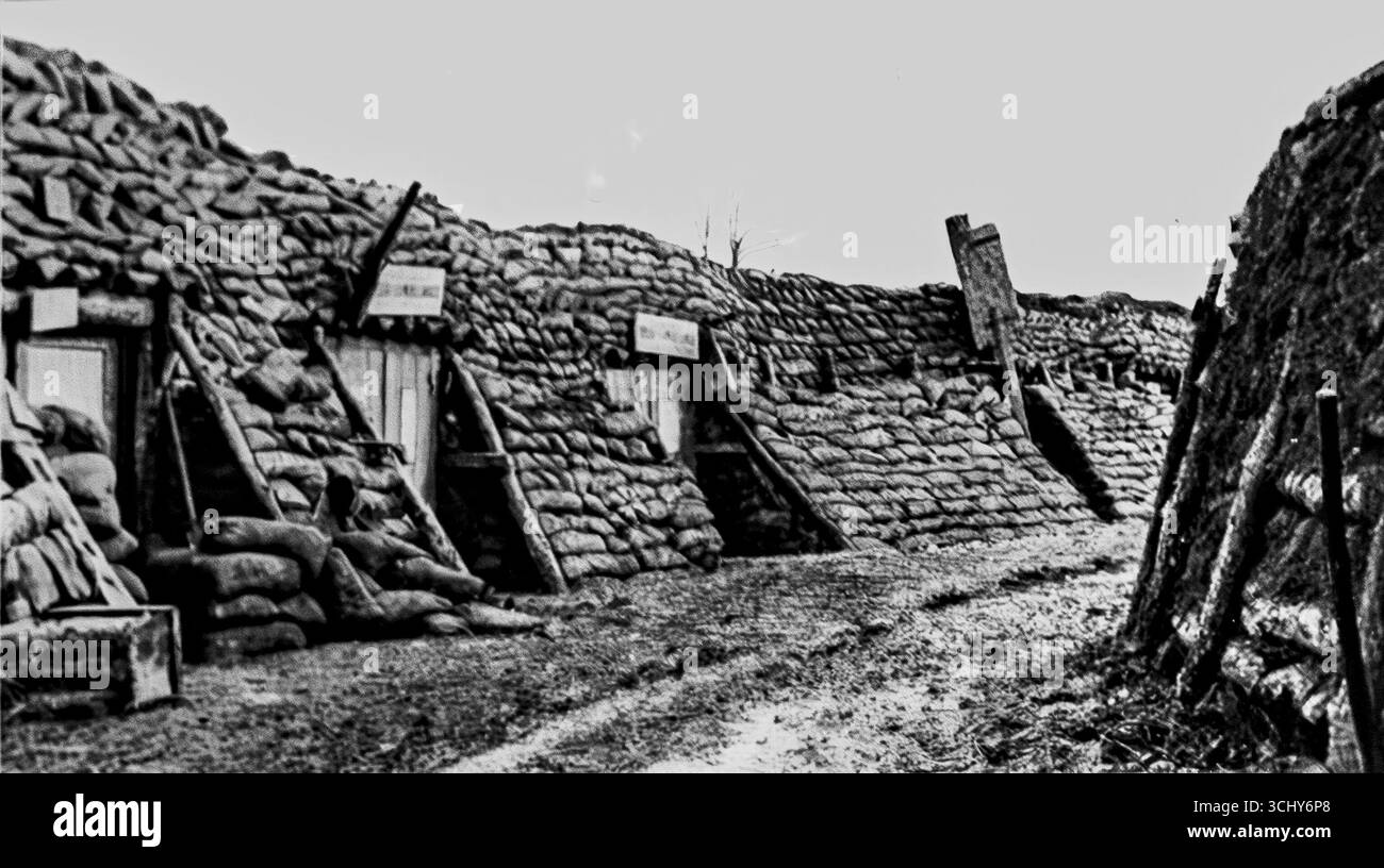 Photo en noir et blanc tirée de L’illustration, 1916, montrant des abris en tranchée ensachés de sacs de sable marqués « Relais d’Ambulance ». Ces duvets de première ligne servaient de postes de secours, abritant les malades, de vestiaires et de quartiers du personnel près du champ de bataille de Champagne. Construits pour résister aux bombardements, ils révèlent l’infrastructure médicale cachée qui a soutenu les soldats français pendant la guerre de tranchées incessante de la première Guerre mondiale. Banque D'Images