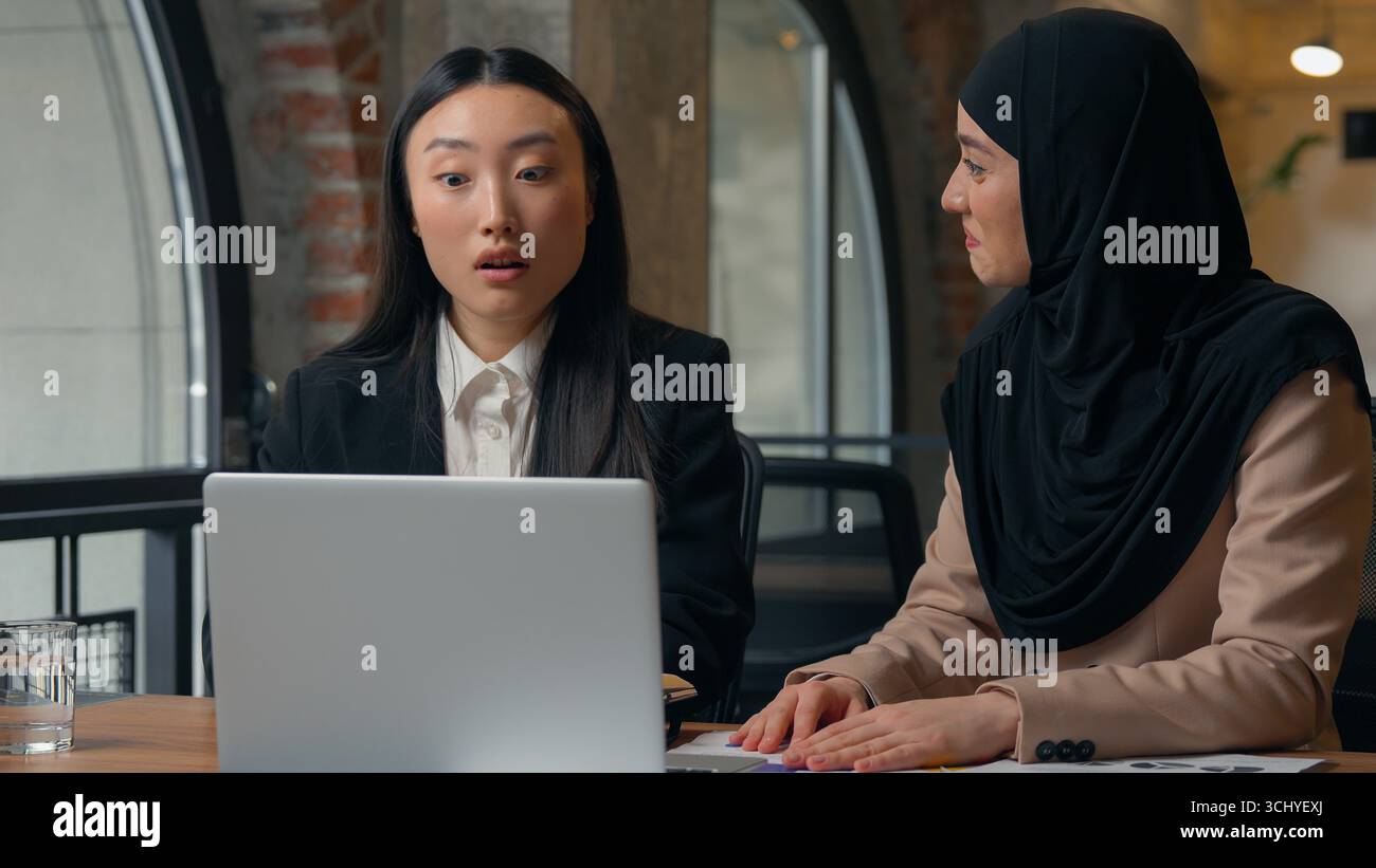 Deux femmes d'affaires de diversité multiraciale collègues employeurs femmes d'affaires multiethniques filles coréennes asiatiques musulmanes surprise parler appel vidéo Banque D'Images
