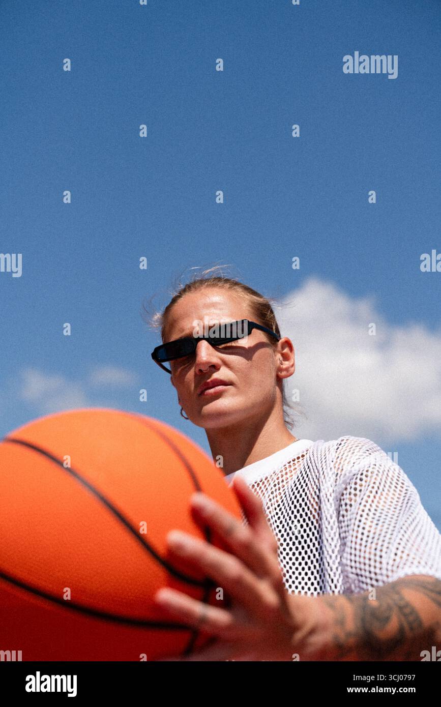 Femme de style urbain avec basket-ball sur le terrain d'été Banque D'Images