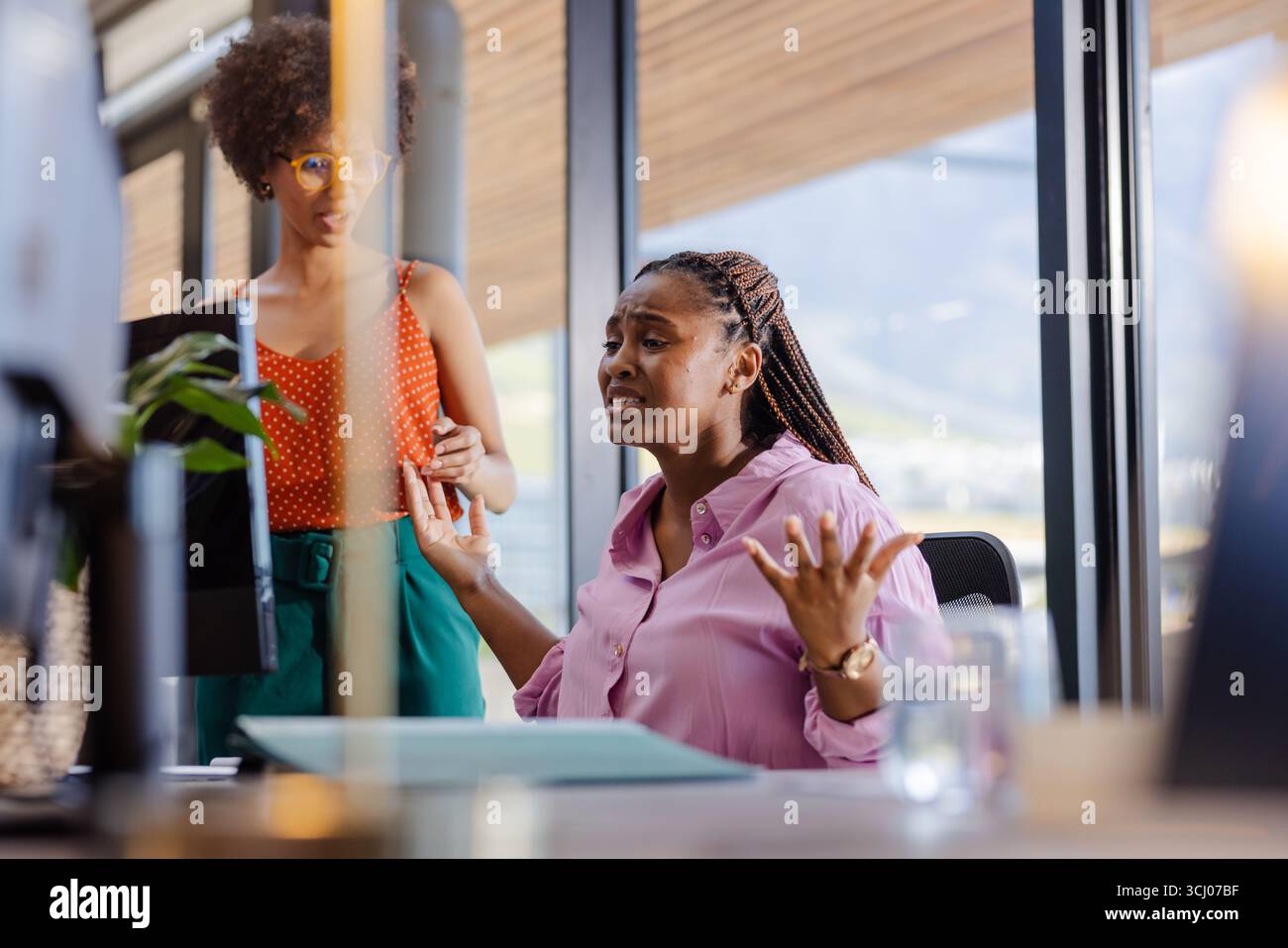 Au bureau, femme d'affaires discutant du projet avec un collègue, exprimant la frustration Banque D'Images