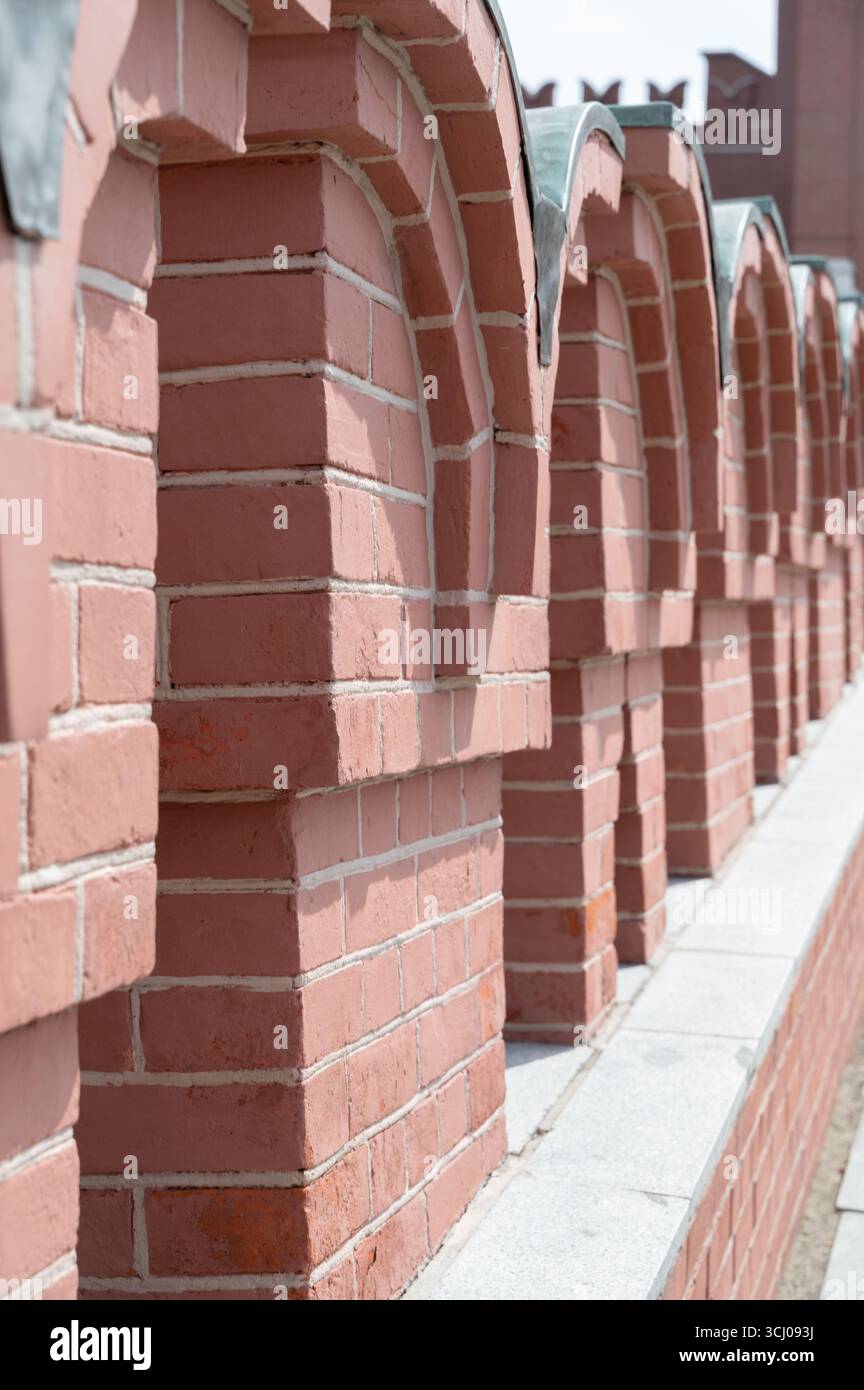 Gros plan d'une structure en briques présentant des arches détaillées et des travaux de maçonnerie, mettant l'accent sur l'artisanat et le design en architecture. Banque D'Images