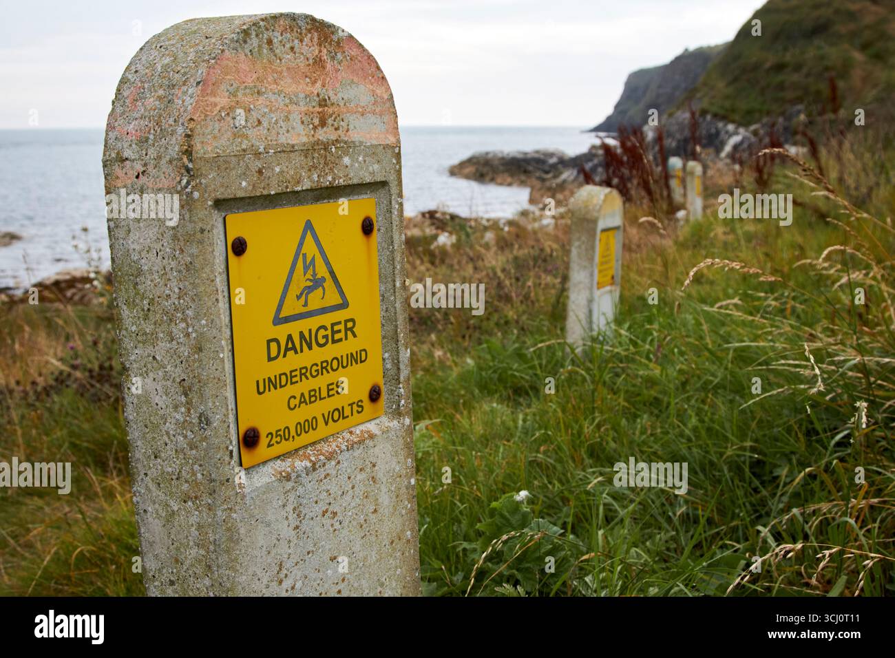 câbles souterrains à haute tension marquant le site d'interconnexion électrique nord-irlandais écosse portmuck county antrim irlande du nord royaume-uni Banque D'Images