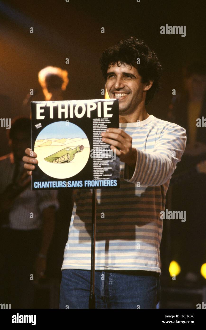 Le chanteur français Julien Clerc tient le disque de la chanson 'Ethiopie' produite par le collectif chanteurs sans frontières pour venir en aide à la population affligée par la famine de l'Ethiopie. Mars 1985 Banque D'Images