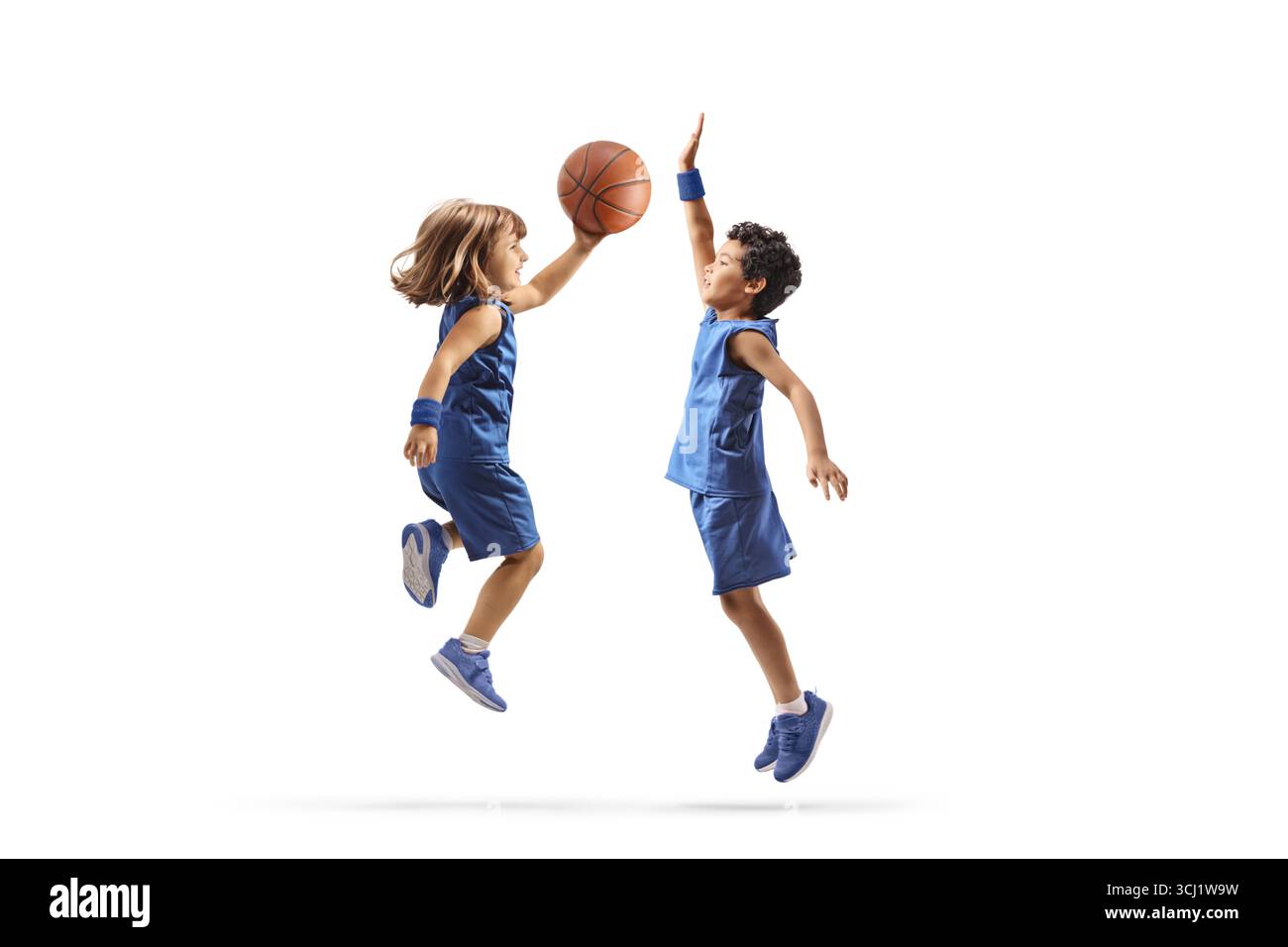 Fille et garçon jouant au basket-ball et sautant isolés sur fond blanc Banque D'Images