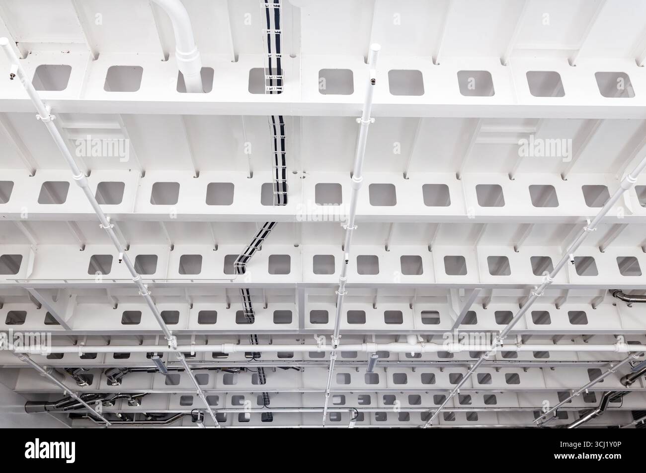 Plafond en acier peint en blanc sur le navire avec raidisseurs, tuyauterie et câblage électrique sur le plafond. Banque D'Images