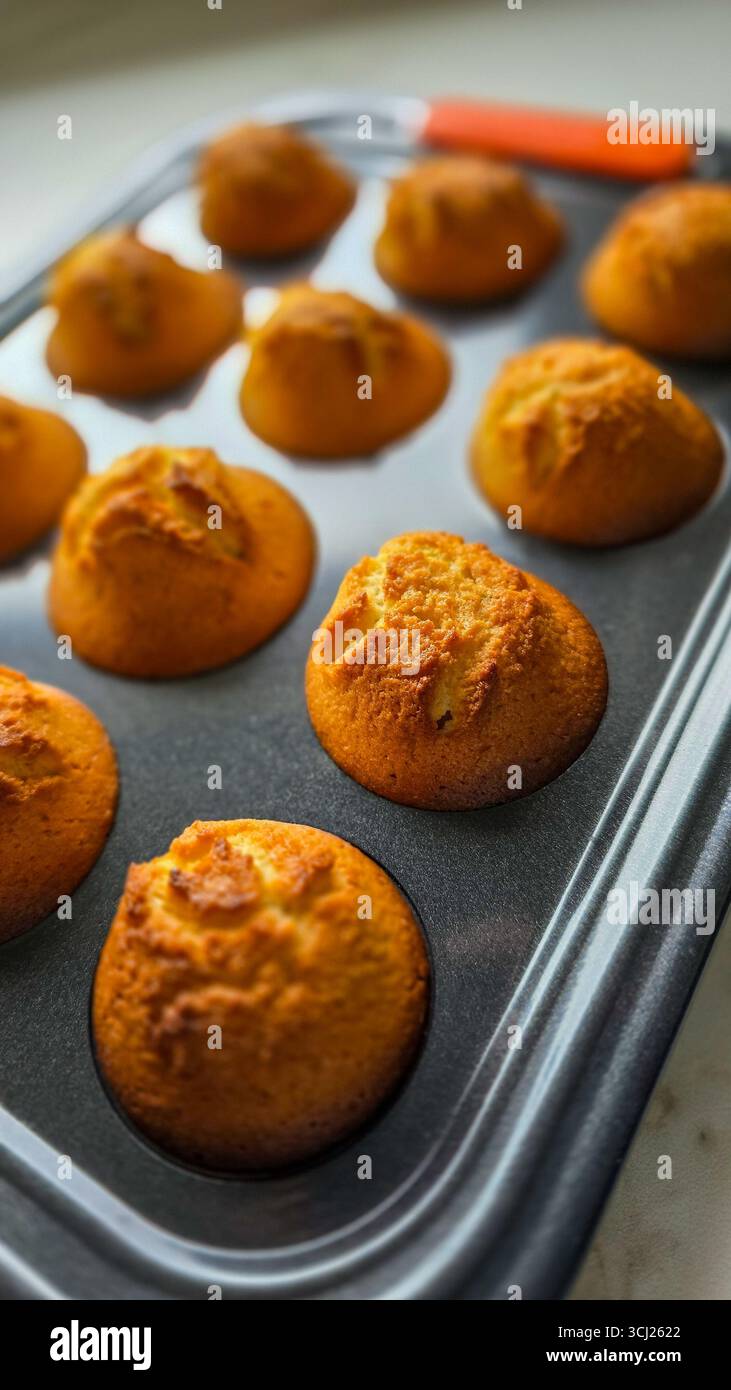 Appétissants muffins au beurre faits maison dans un moule à muffins noir. Cuisson facile Banque D'Images