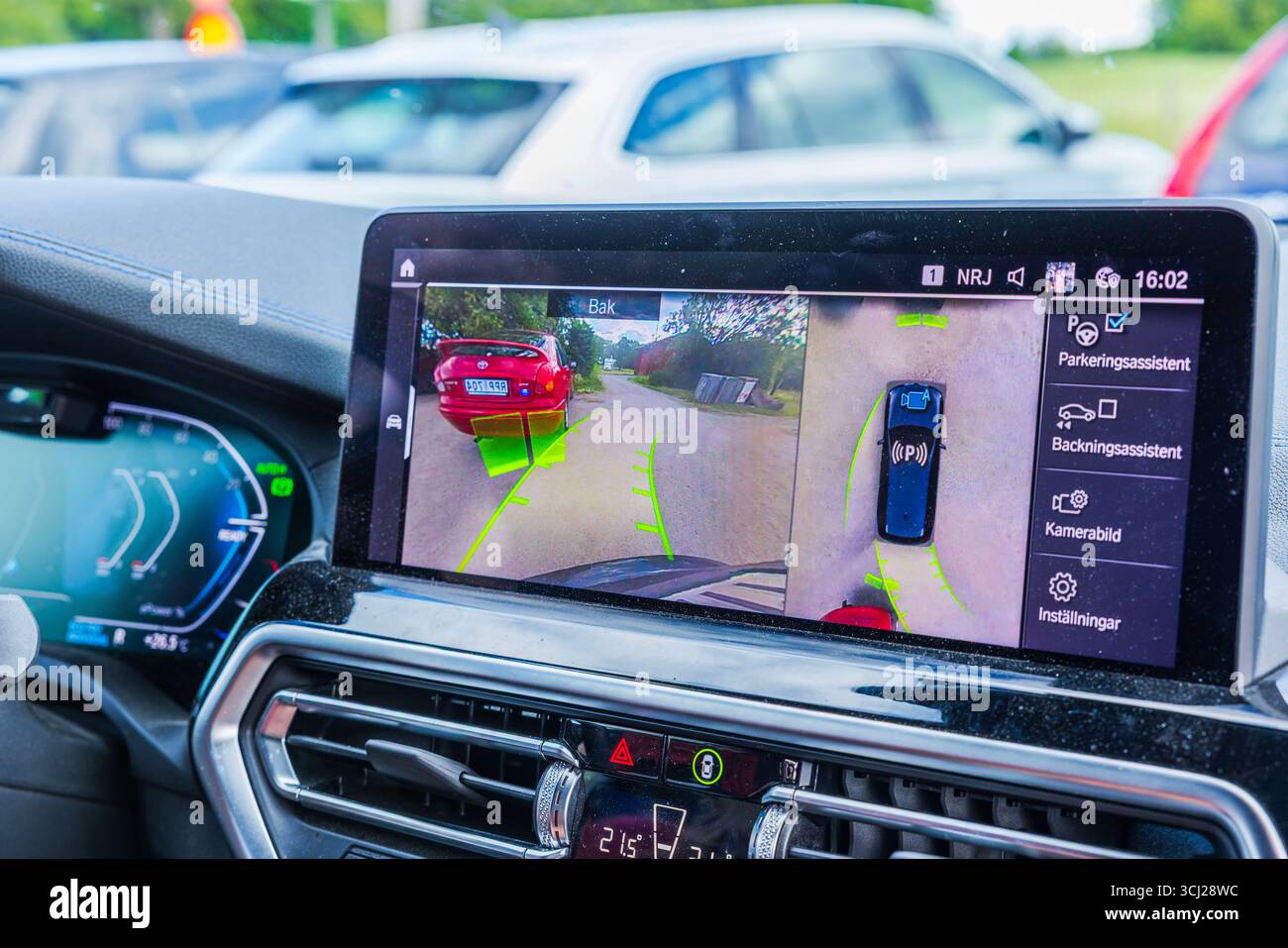 Vue rapprochée de l'écran de voiture électrique BMW iX3 M montrant la caméra de recul et le système d'aide au stationnement. Suède. Uppsala. Banque D'Images