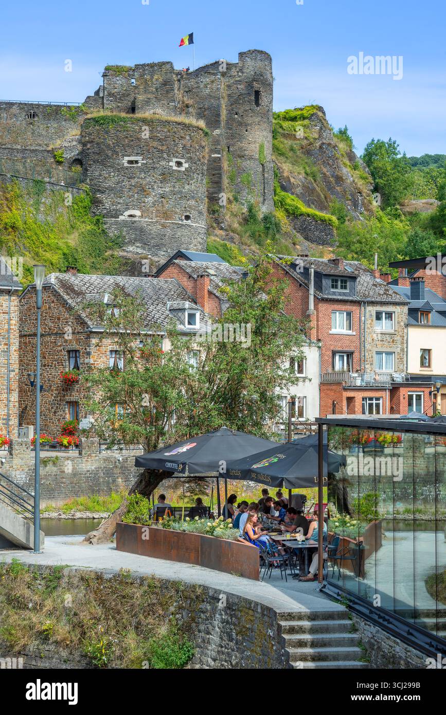 Touristes au restaurant le long de la rivière Ourthe et château en ruines dans la ville la Roche-en-Ardenne, province de Luxembourg, Ardennes, Wallonie, Belgique Banque D'Images