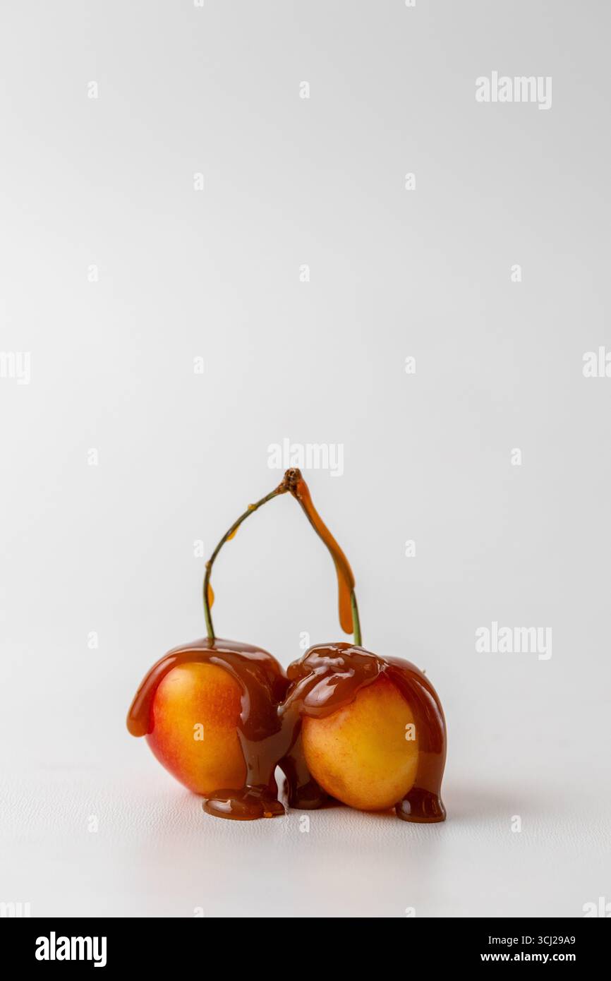 Cerises Rainier à la sauce Carmel, sur un fond blanc, image conceptuelle avec espace de copie Banque D'Images